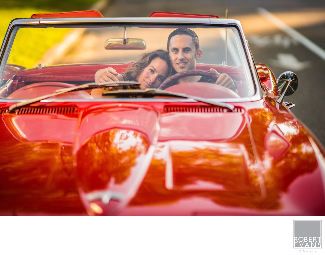 A relaxed lifestyle portrait of a couple sharing a quiet moment together in a classic red convertible, creating a fun and personal image that reflects their connection.