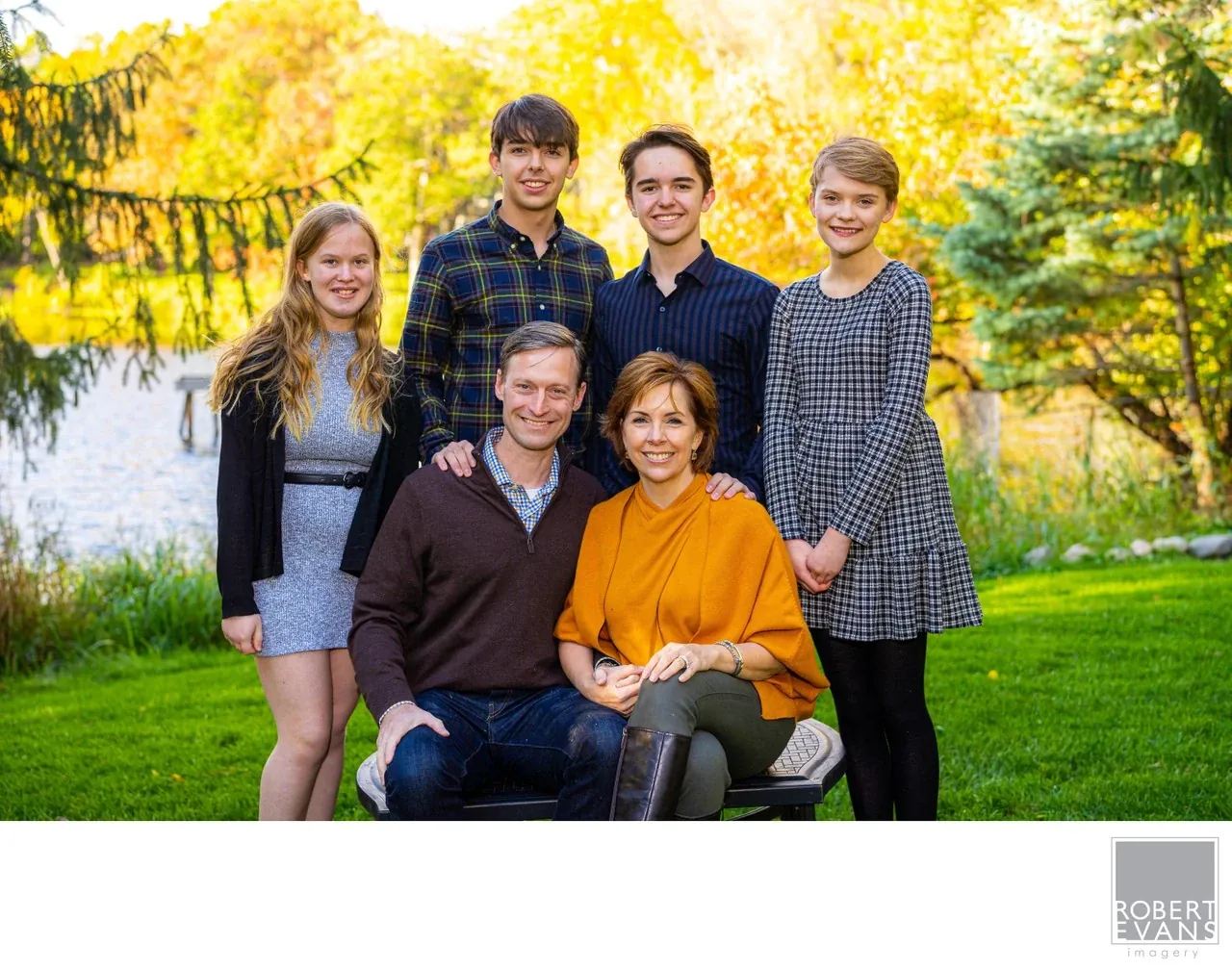 A relaxed family portrait surrounded by colorful autumn foliage.