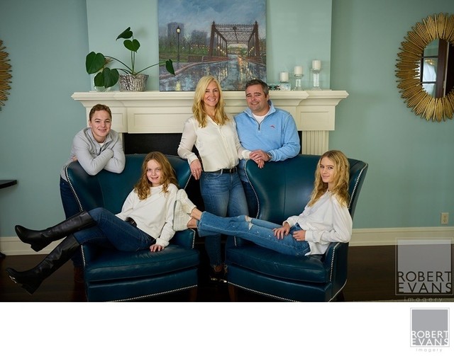 A casual family portrait photographed at home, creating a comfortable setting where personality and genuine family connections come through naturally.