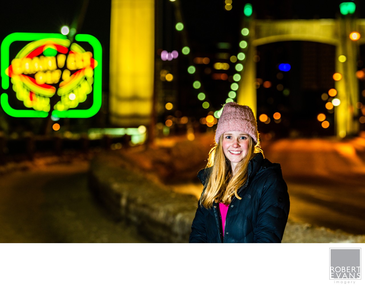 A fun nighttime portrait using colorful lights and the surrounding environment to create a vibrant, personality-filled image in downtown Minneapolis.