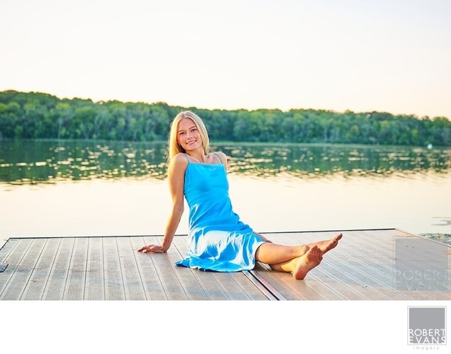 A relaxed summer portrait photographed at the water's edge, using the lake, evening light and open landscape to create a timeless environmental portrait at the client’s home.