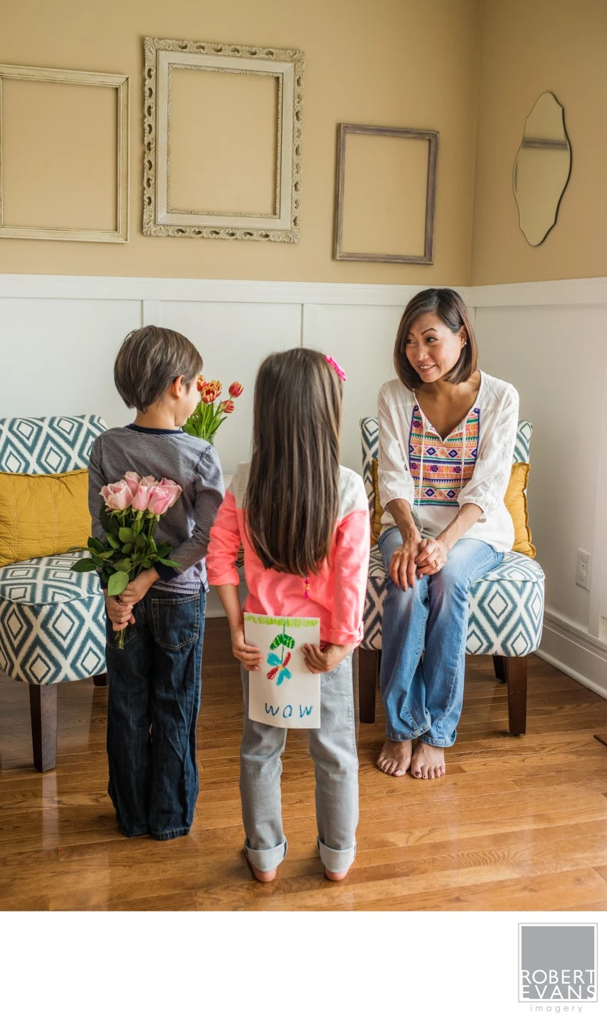 A sweet Mother's Day moment between a mother and her children, photographed at home to preserve the genuine expressions and connections of family life.