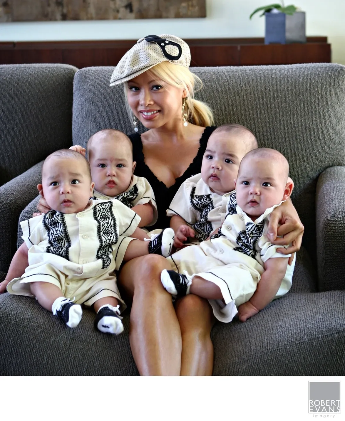 A mother holds her four baby quadruplets together for a memorable in-home family portrait, capturing an extraordinary moment during their first year.