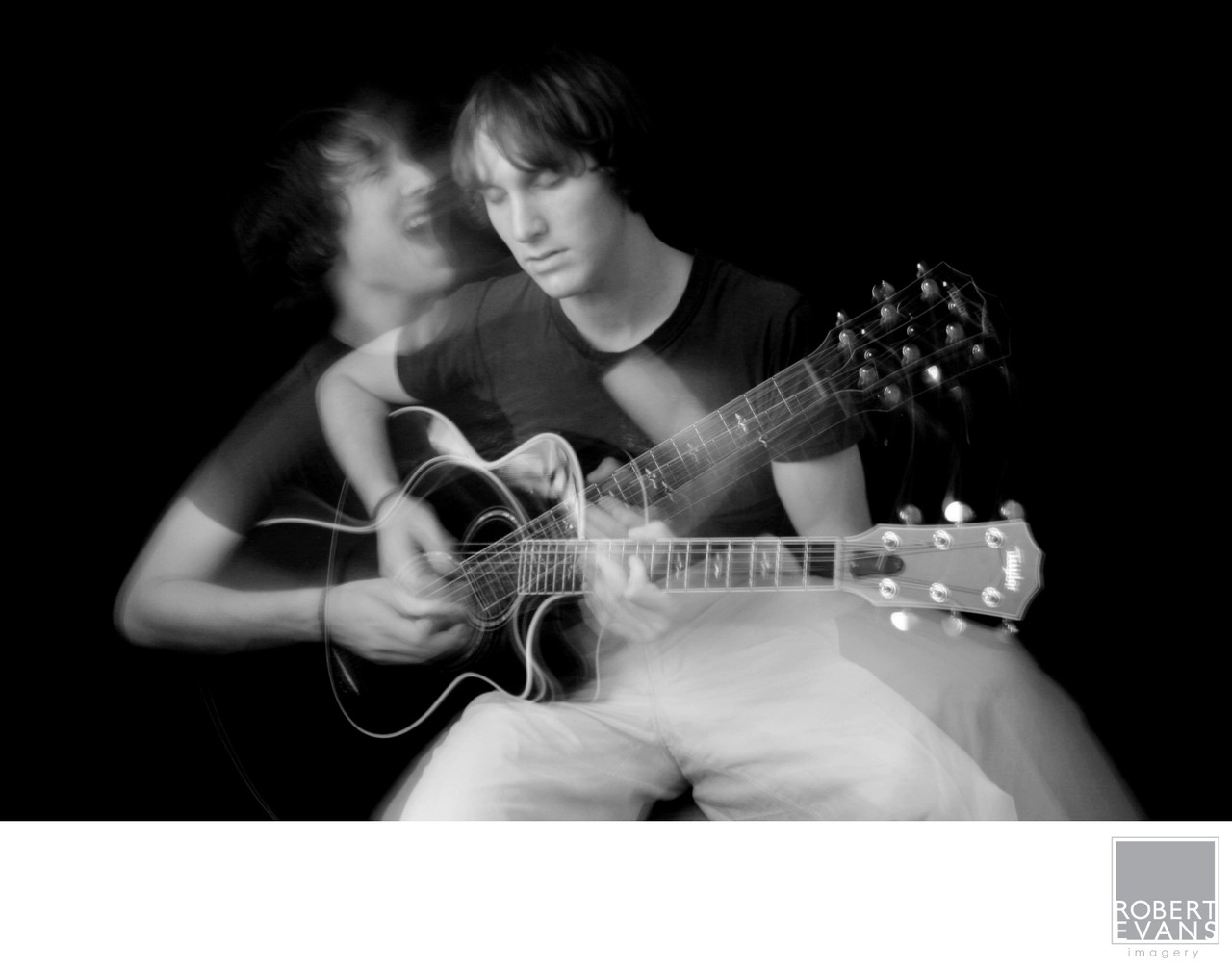 Artistic black and white portrait of a young guitarist captured with motion and multiple exposure effects.