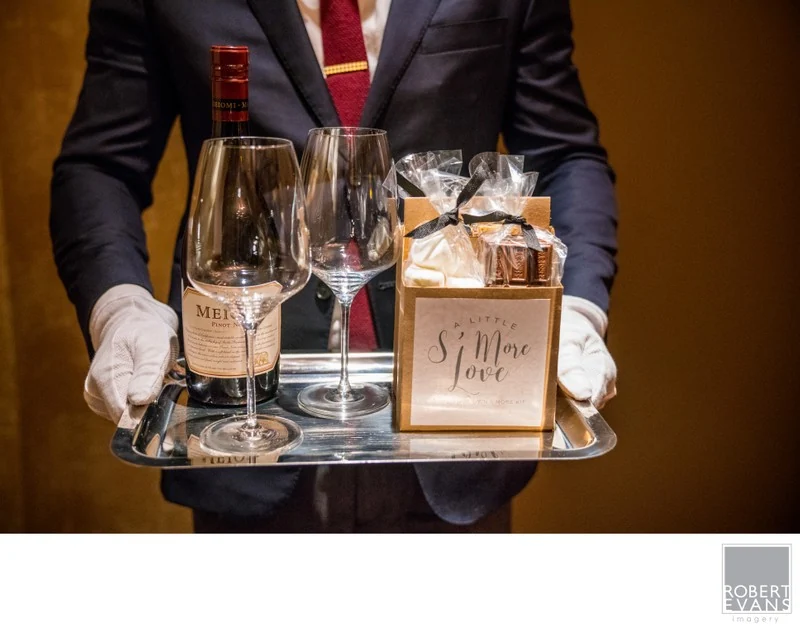 A server carrying a tray of champagne glasses and a small table sign.