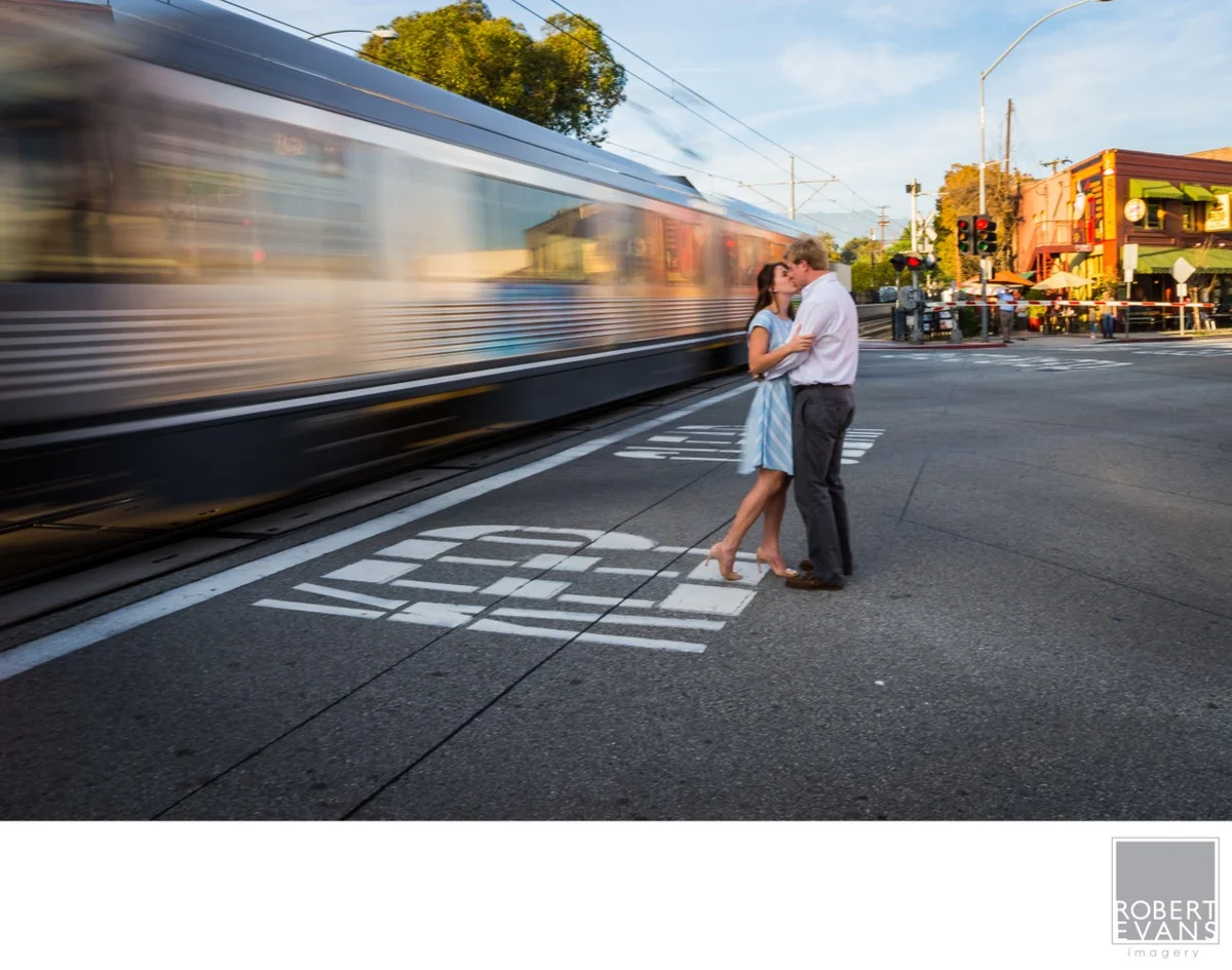 A couple embraces as a train passes through the city.