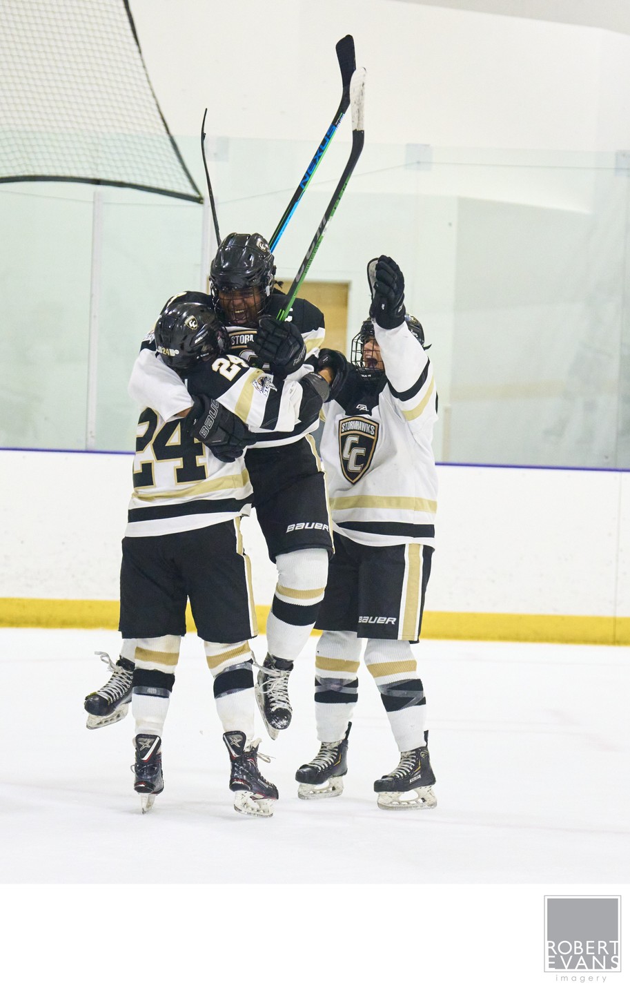 Hockey teammates gather with sticks raised after a play.