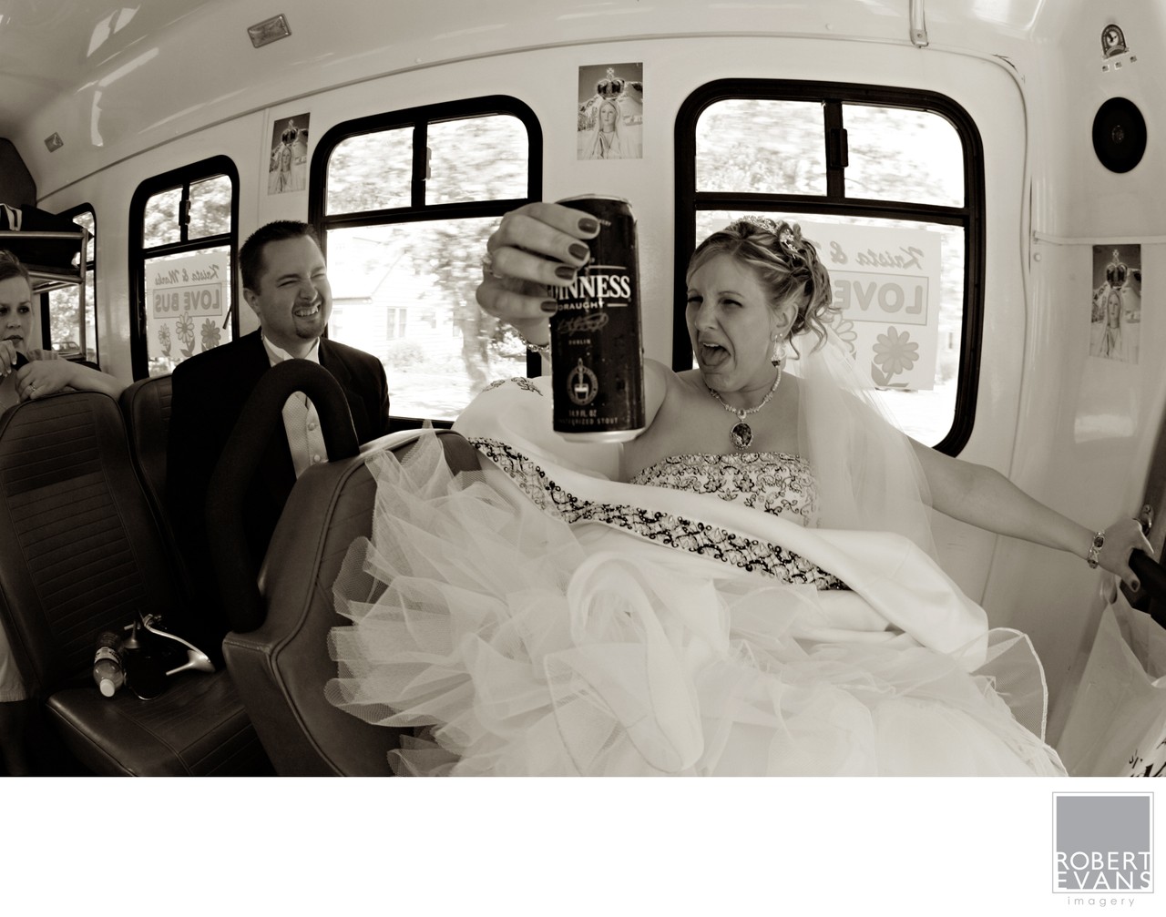 A bride and groom sit together inside a bus in a candid monochrome photograph.