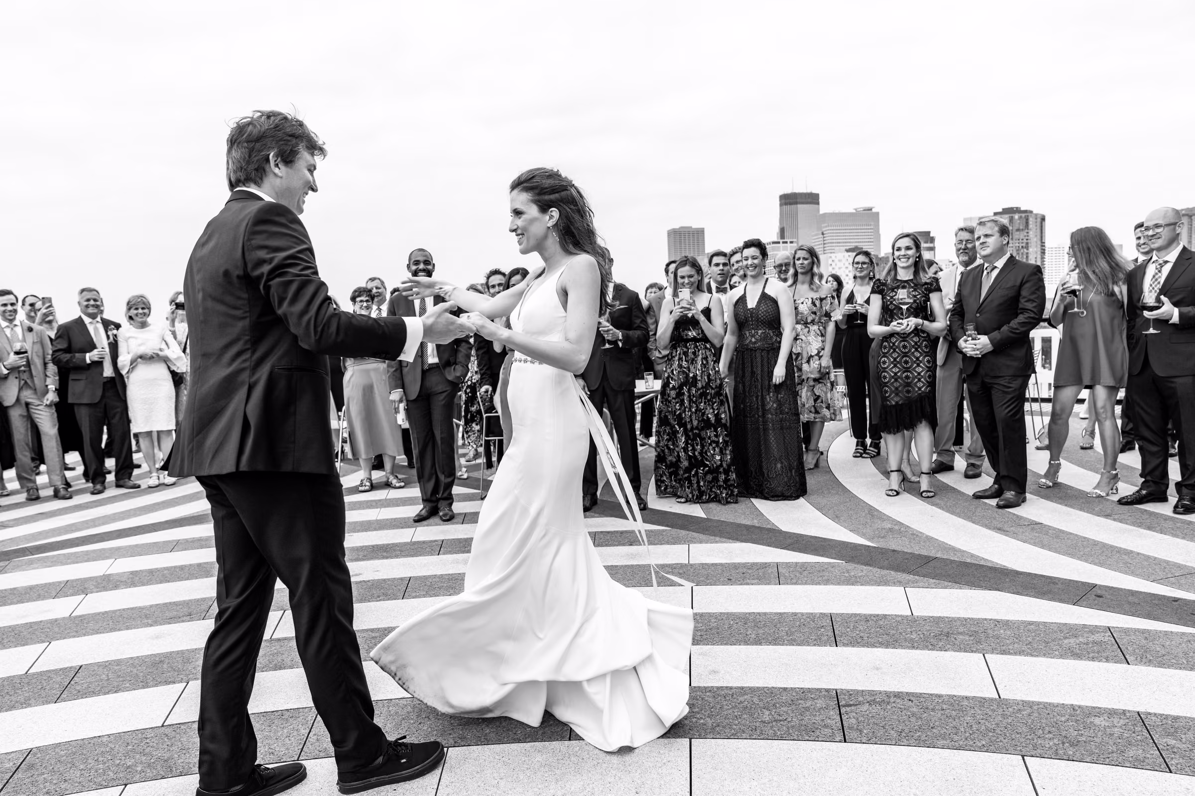 Black-and-white photograph of Ali and Drew dancing on the Walker terrace as guests watch