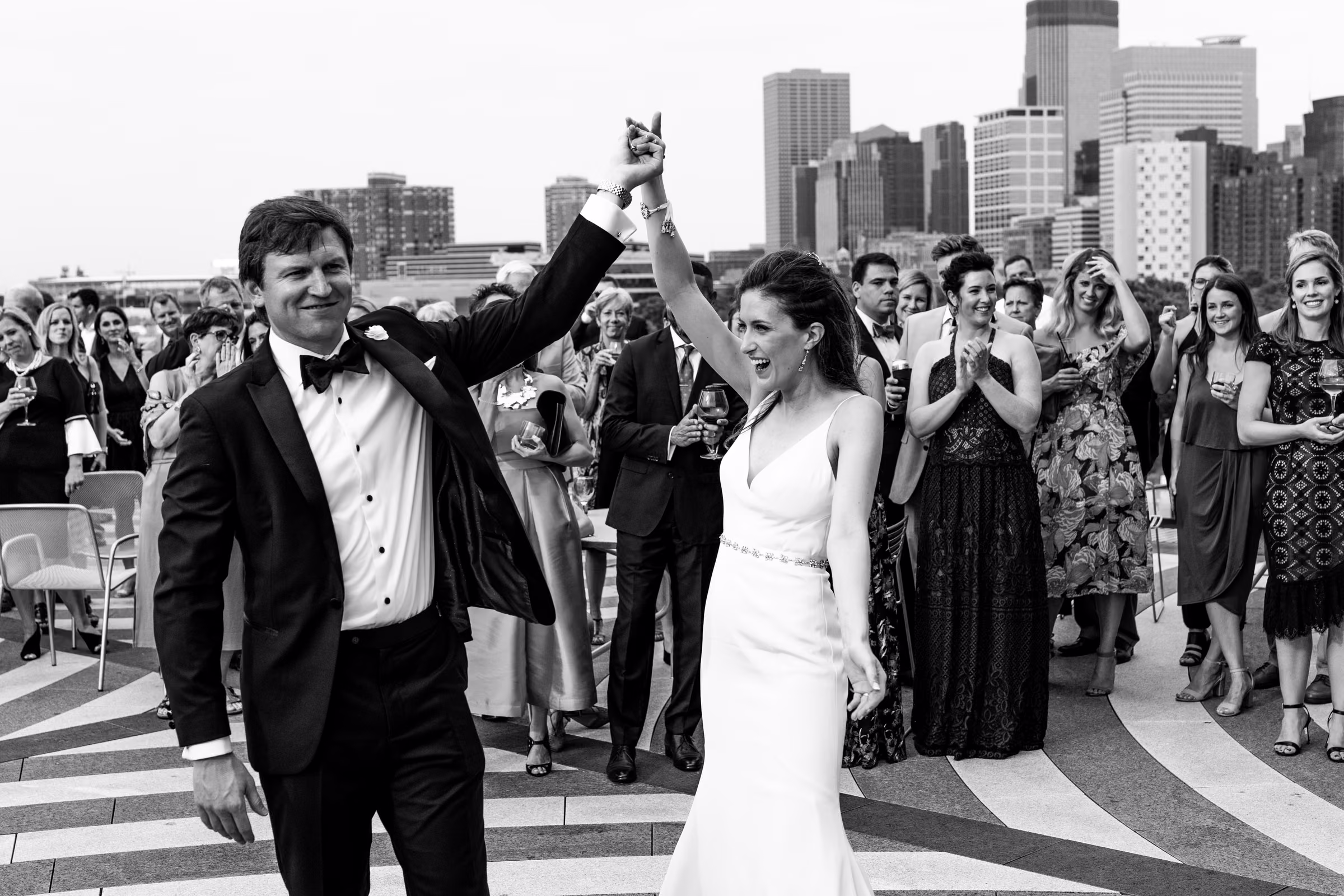 Drew twirls Ali during their terrace first dance with the Minneapolis skyline behind them