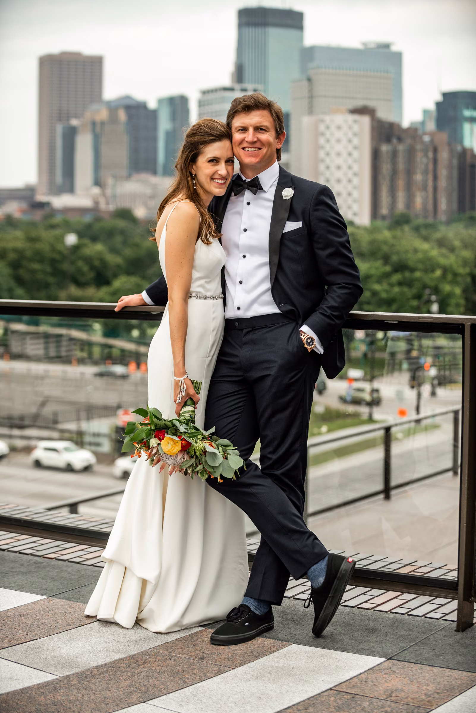 Ali and Drew stand together on the Walker terrace with downtown Minneapolis in the background