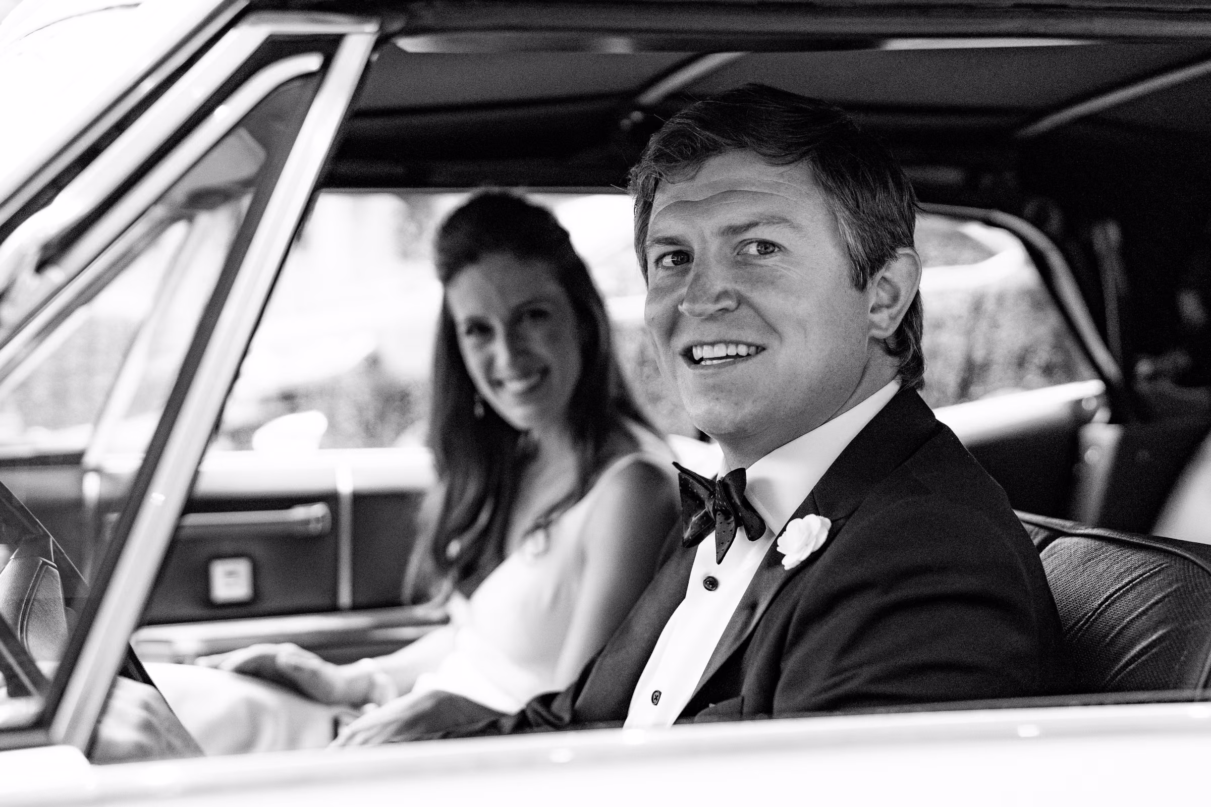 Drew smiles from the driver’s seat of the vintage Cadillac with Ali beside him