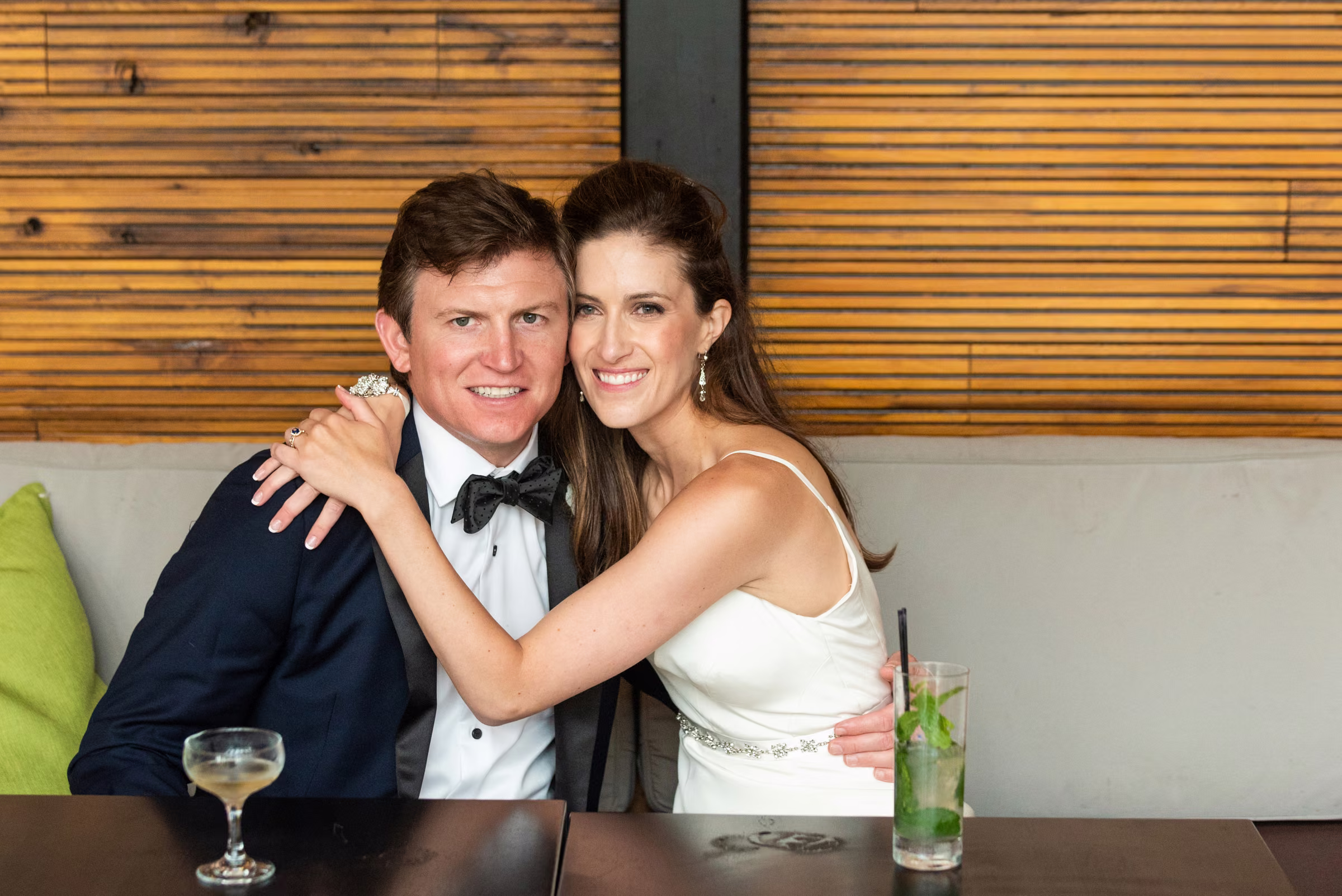 Ali and Drew sit together in a booth at 4 Bells with drinks on the table