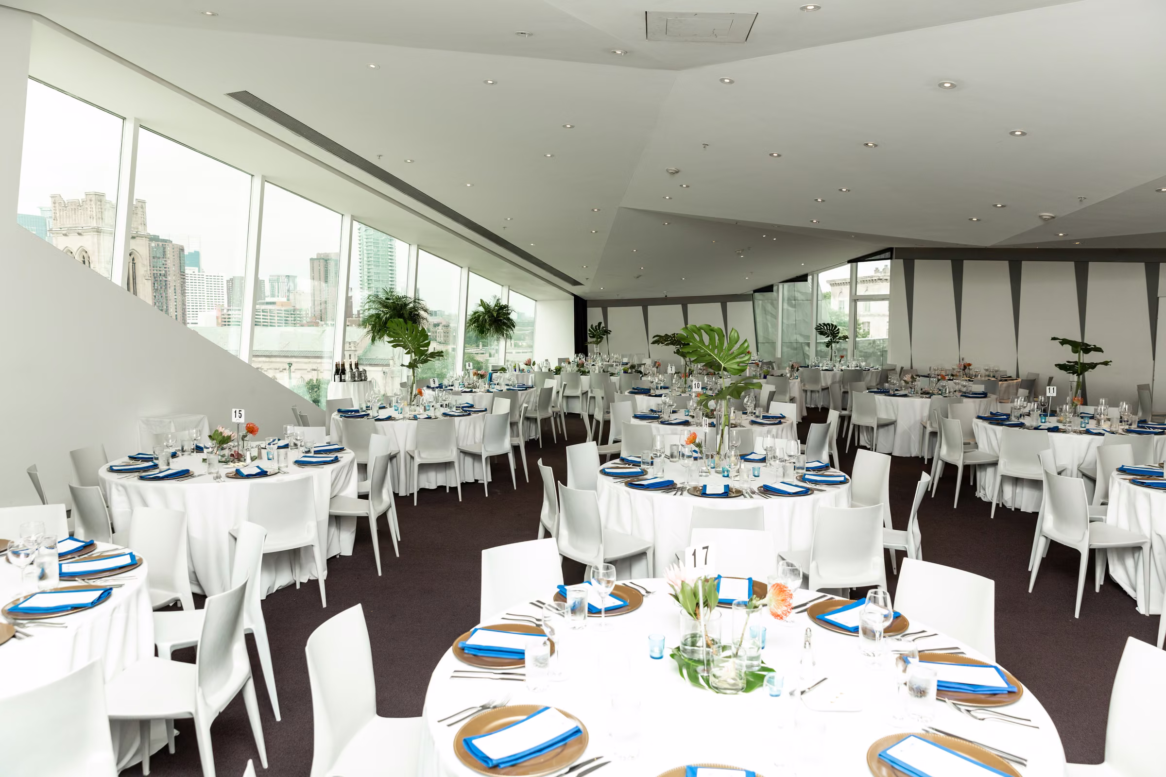 Wide view of the modern Walker Art Center reception room with tables set beside tall windows