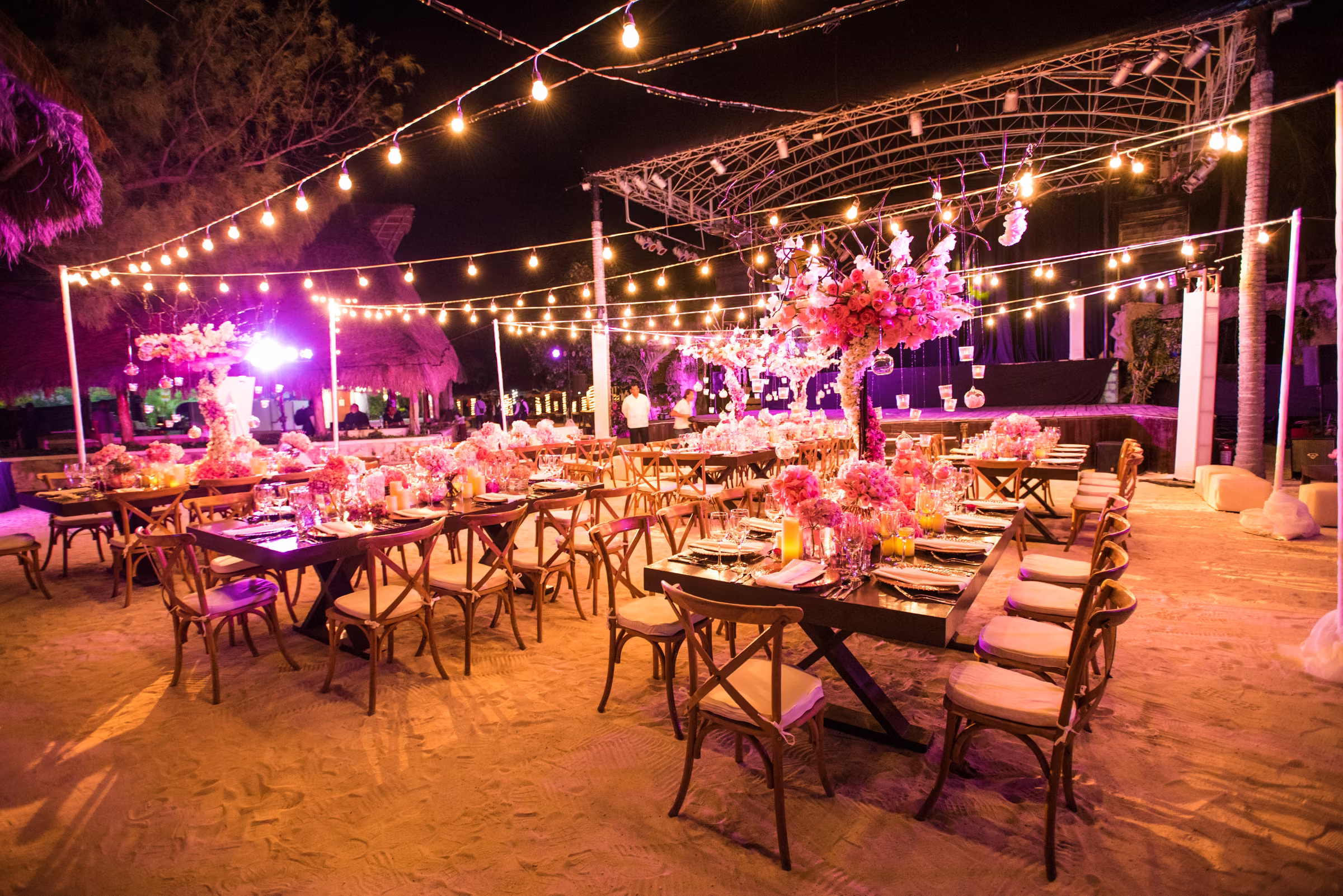 Welcome dinner tables and a performance stage glow beneath strings of lights