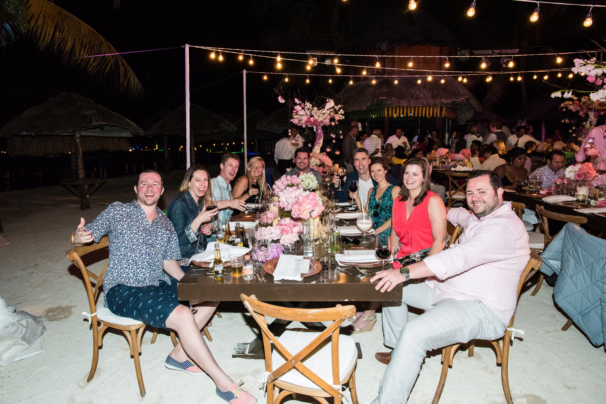 Guests smile around a long outdoor table during the welcome dinner