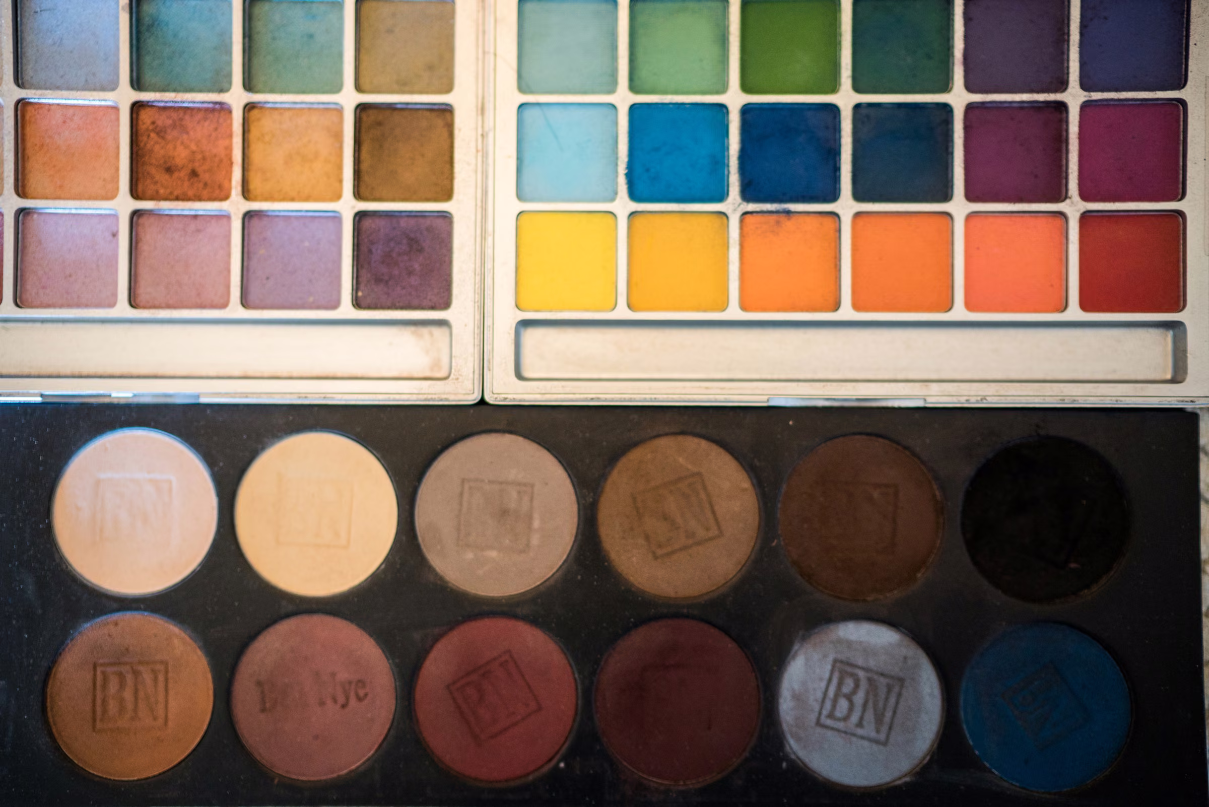 Open makeup palettes display rows of colors during wedding preparations