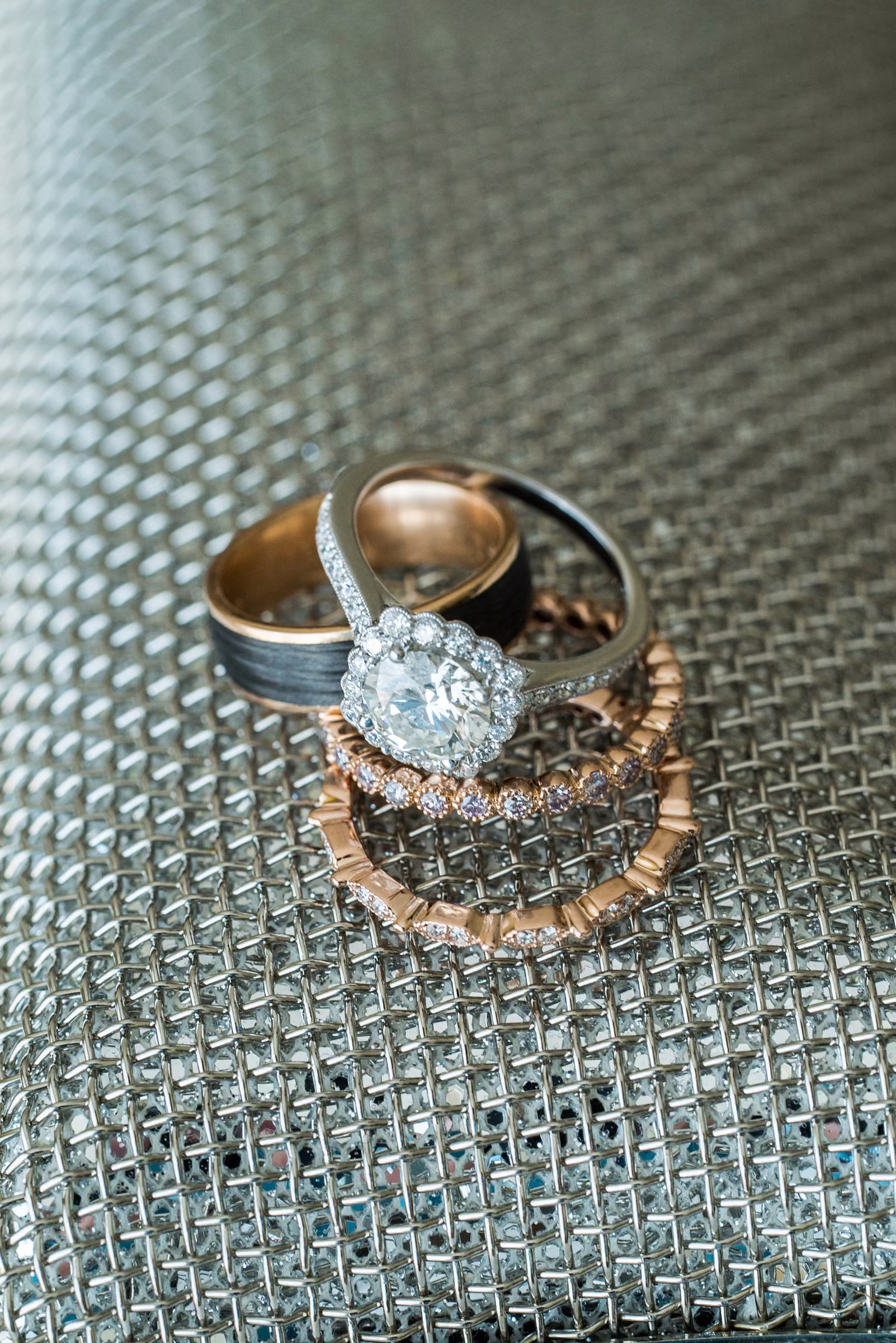 Wedding rings rest together on a textured surface