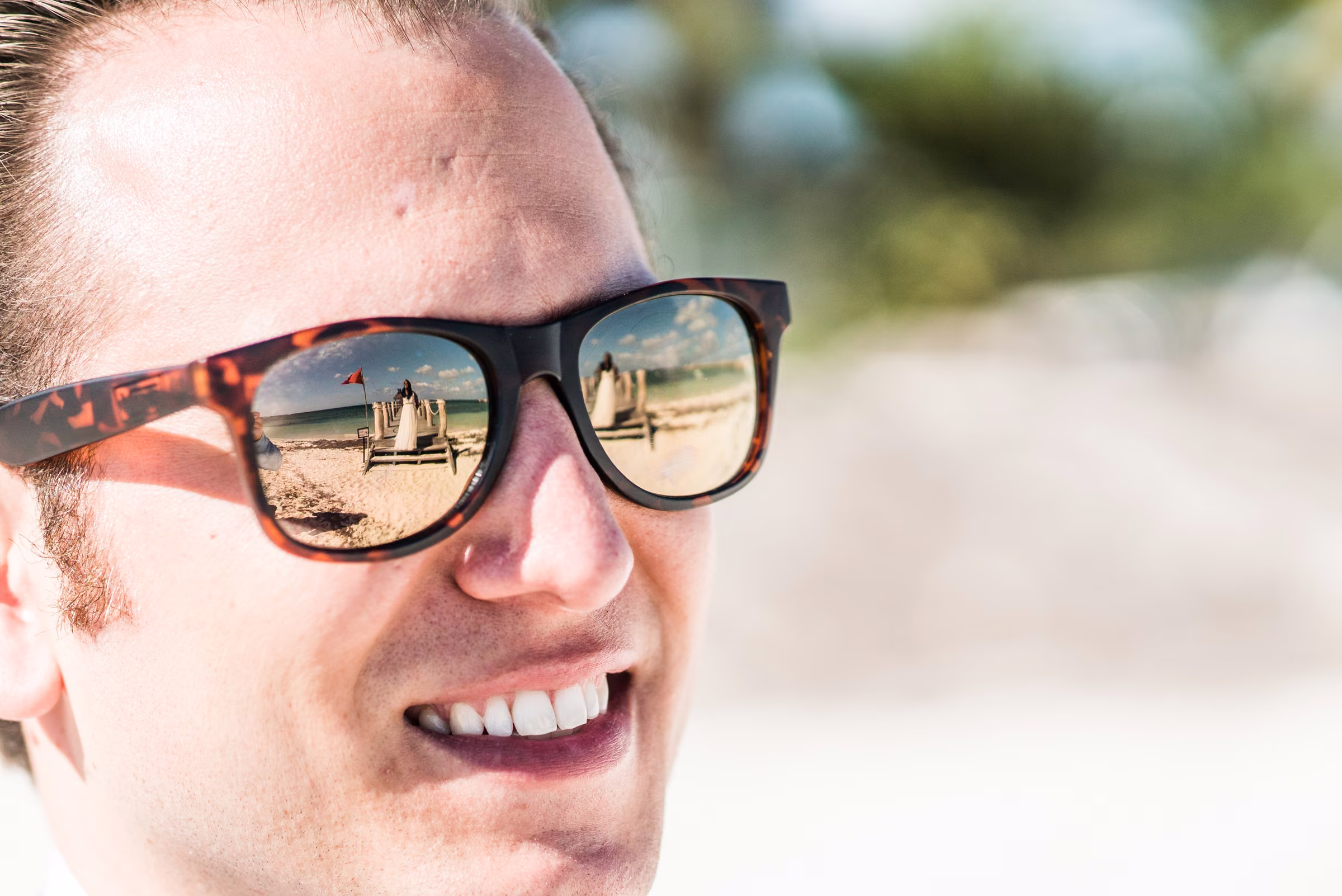 Avanti is reflected in Tony’s sunglasses as he smiles at her