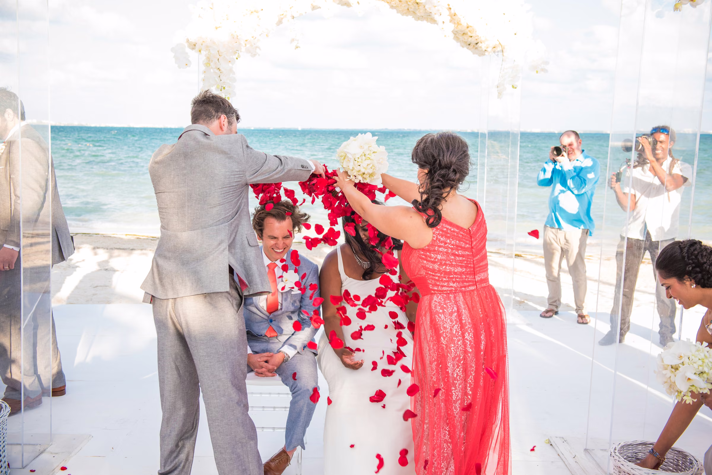 Family members reach over Avanti and Tony to shower them with red rose petals
