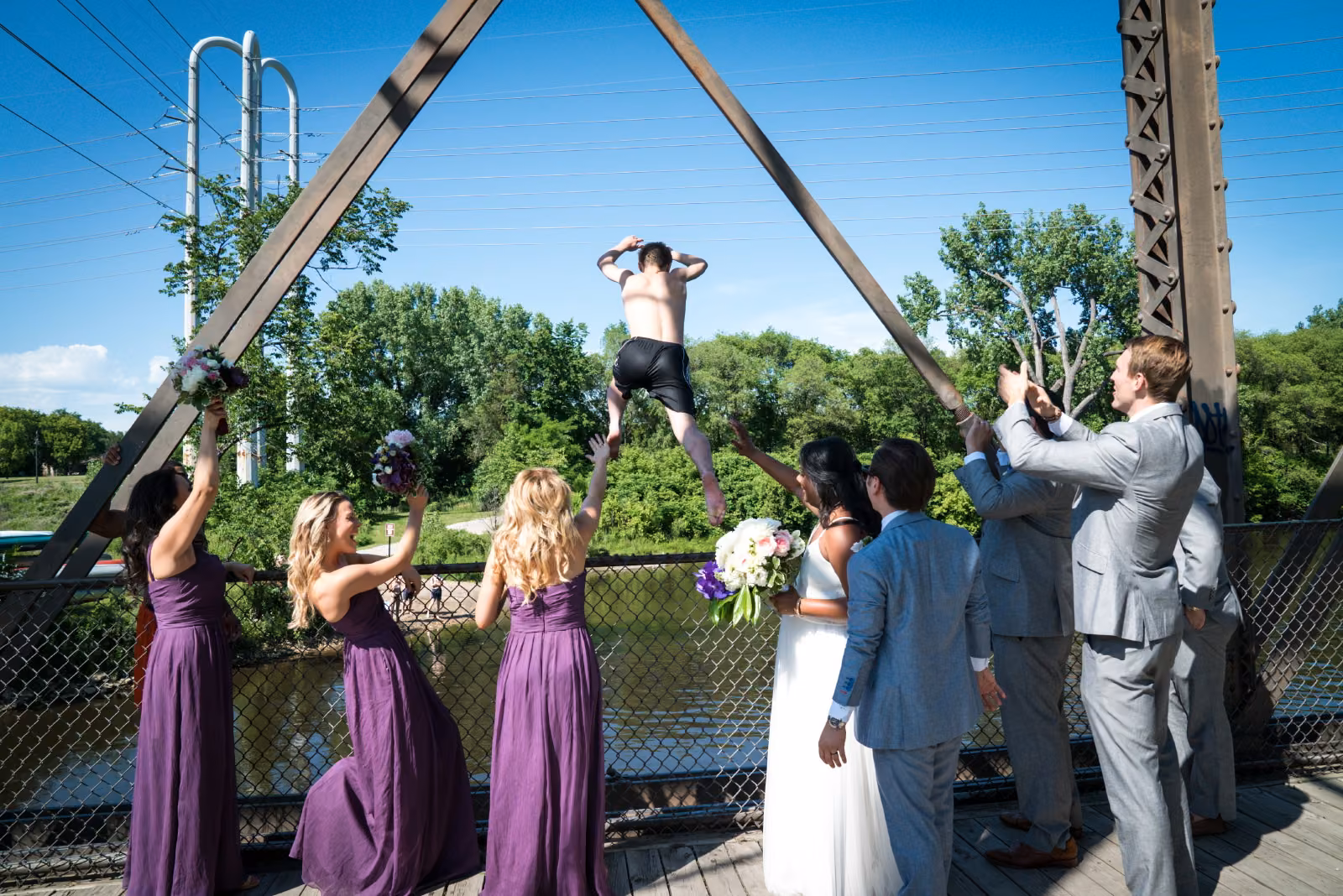 Avanti and Tony’s wedding party watches a young man standing on the bridge rail above the Mississippi River