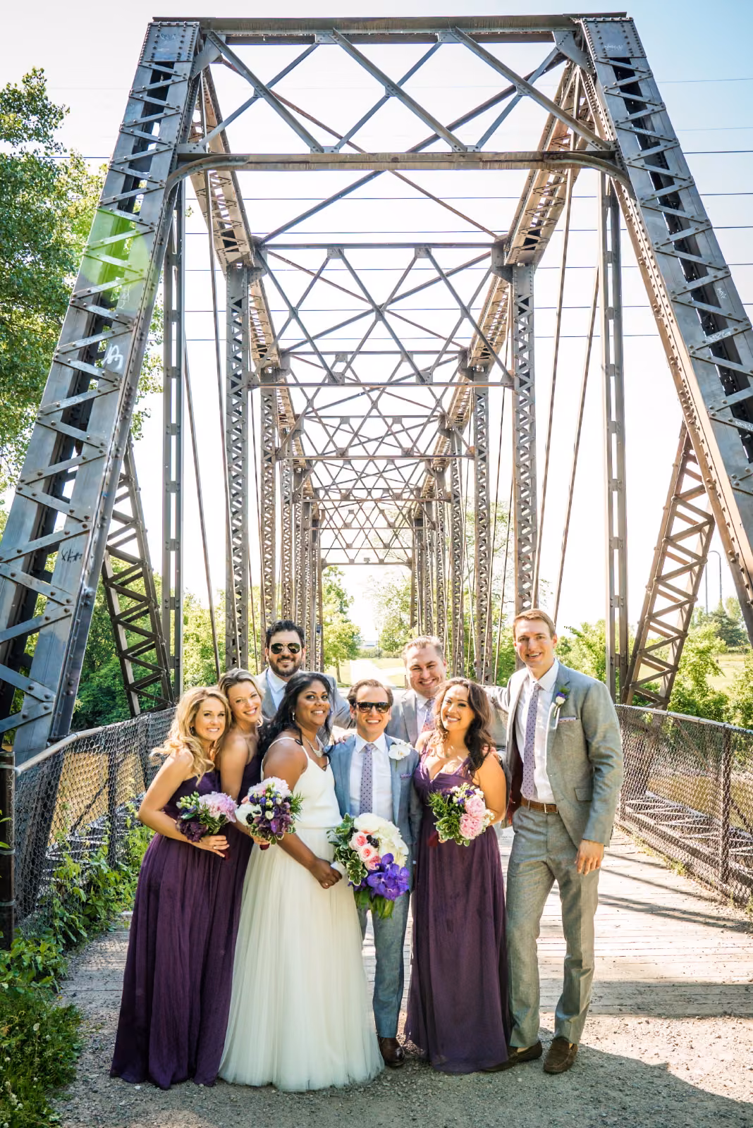 Avanti and Tony gather with their wedding party beneath the steel framework of a Minneapolis bridge