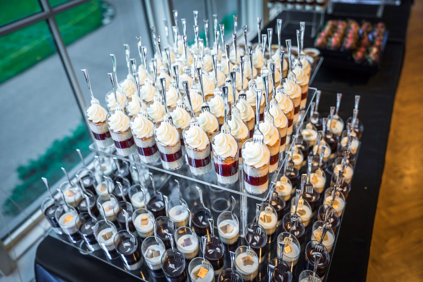 Small dessert glasses and spoon-topped treats are arranged in rows on a table at Interlachen Country Club