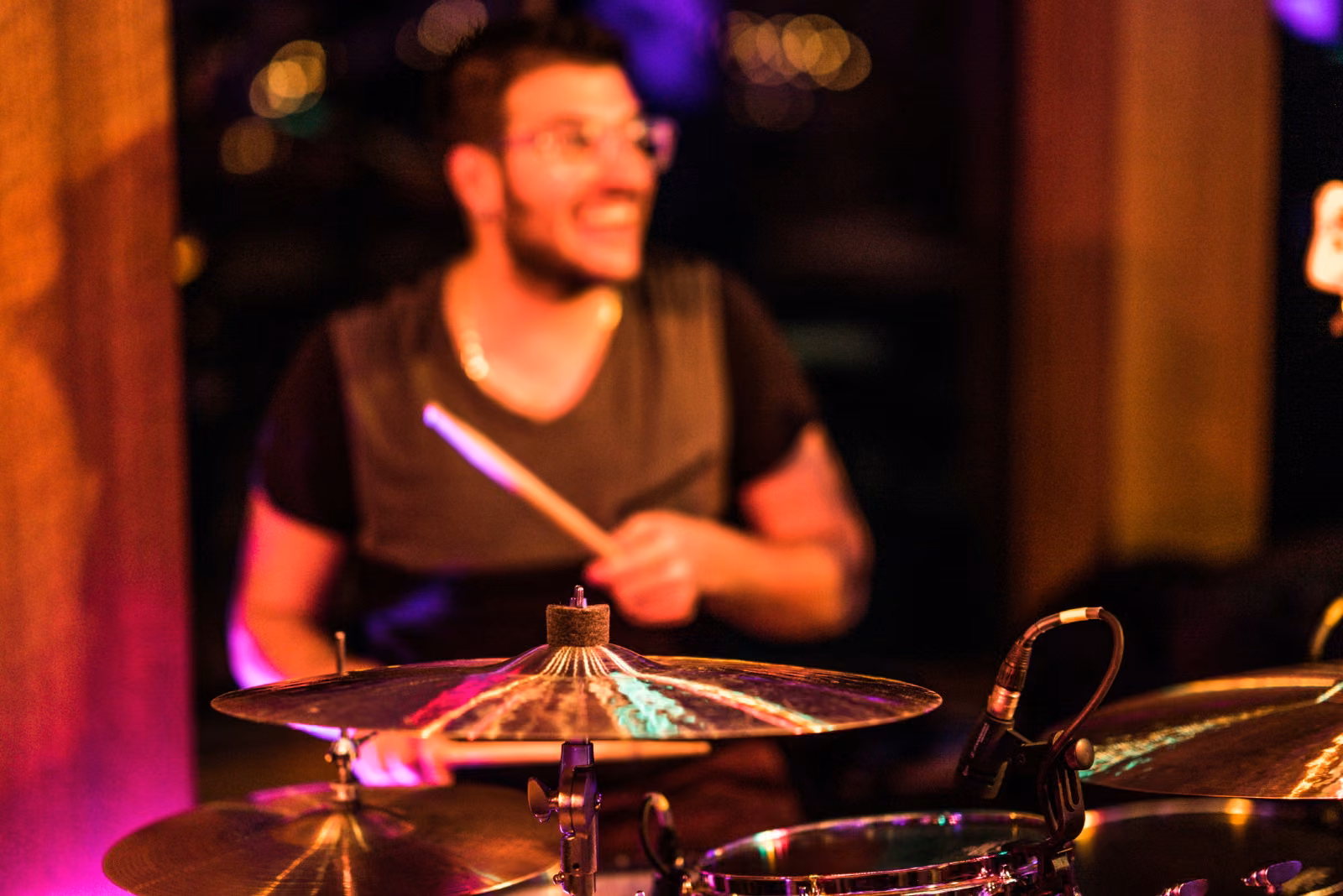 A smiling drummer plays during Avanti and Tony’s wedding reception at Interlachen Country Club