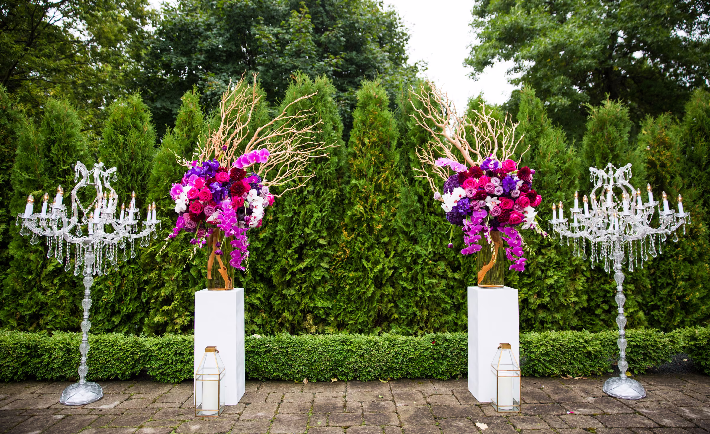 Vivid pink and purple flowers stand beside crystal chandeliers in the garden of a private Wayzata estate