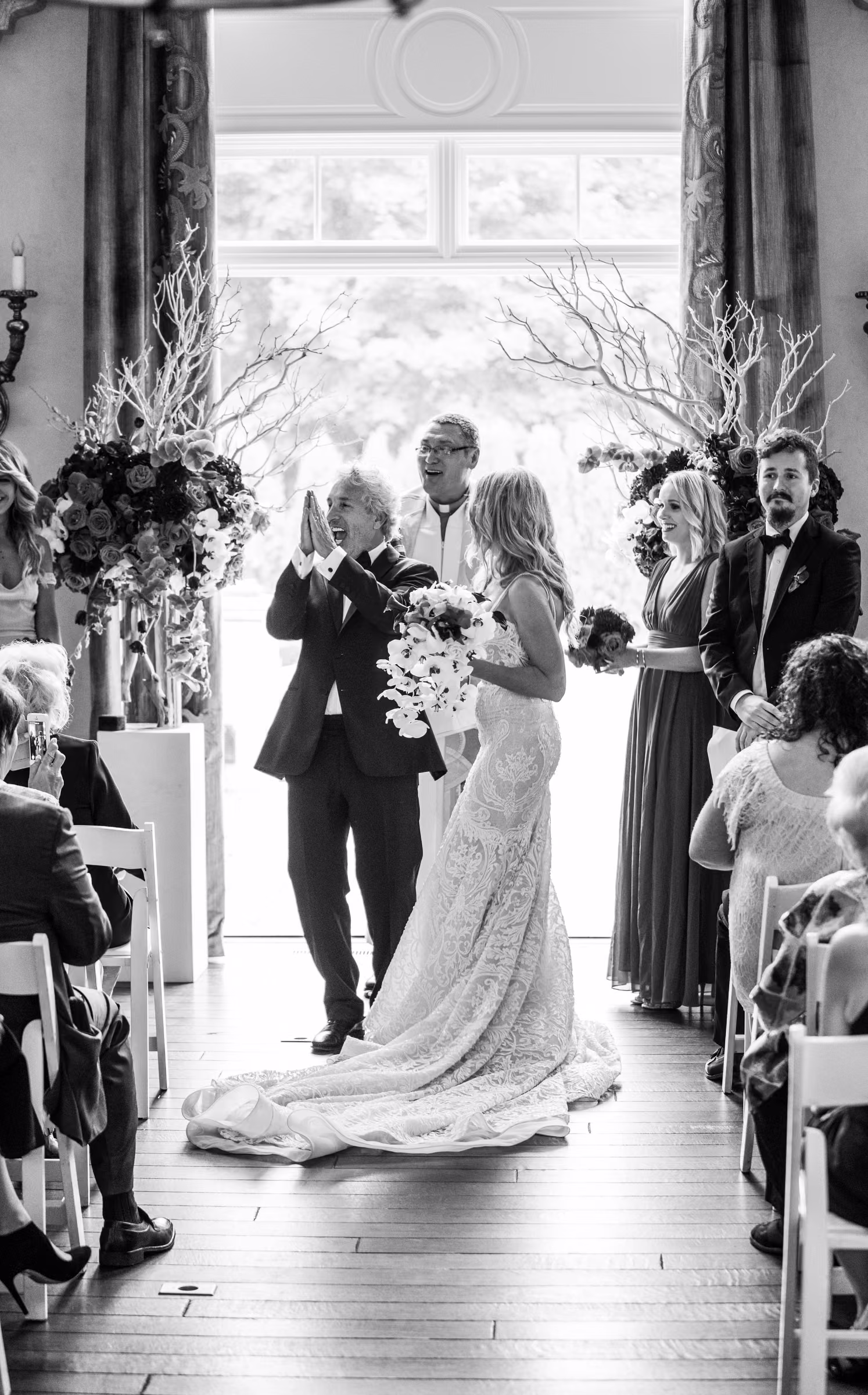 Bill raises his arms in celebration beside Daiva after they are pronounced married