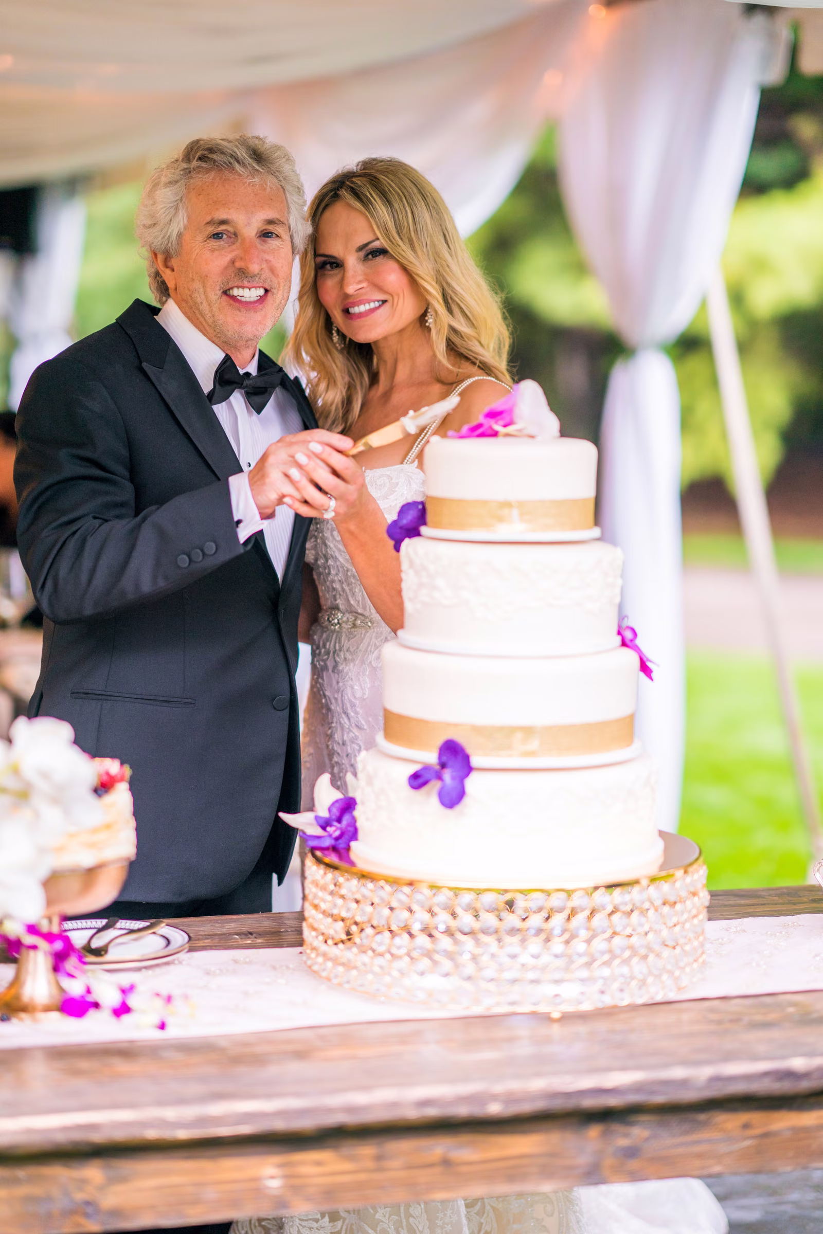 Bill and Daiva smile as they cut their wedding cake together
