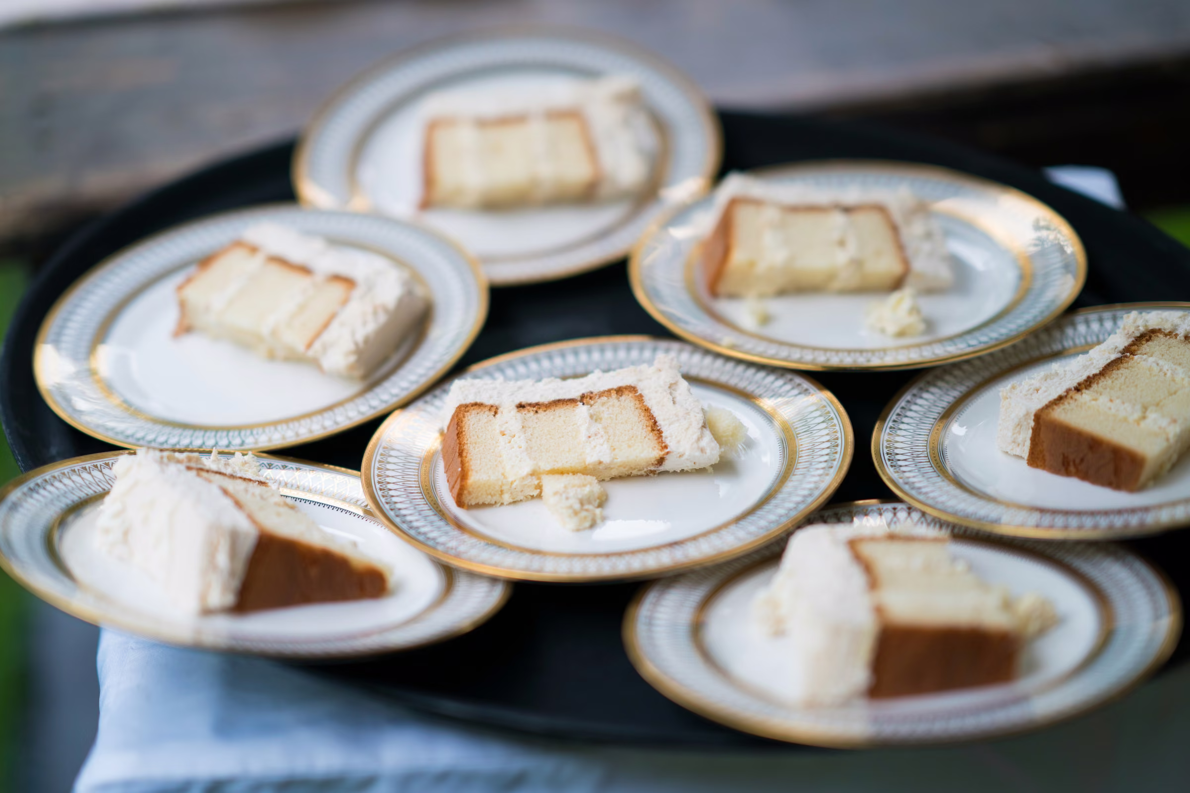 Slices of wedding cake are arranged on gold-rimmed plates