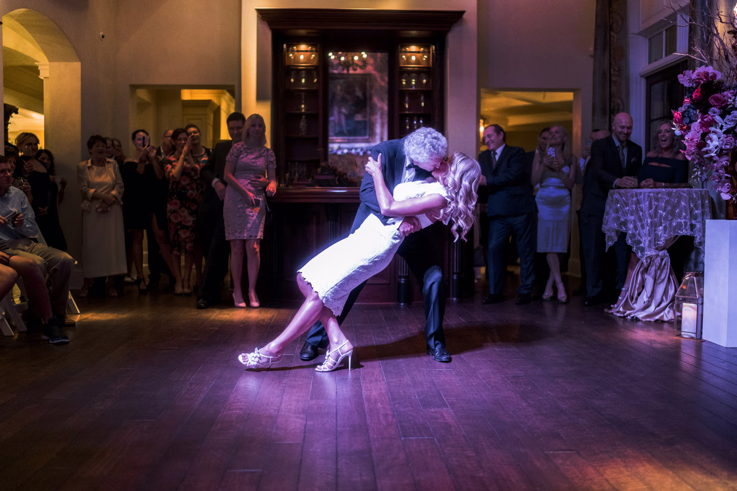 Bill dips Daiva at the end of their first dance in a pool of colorful light