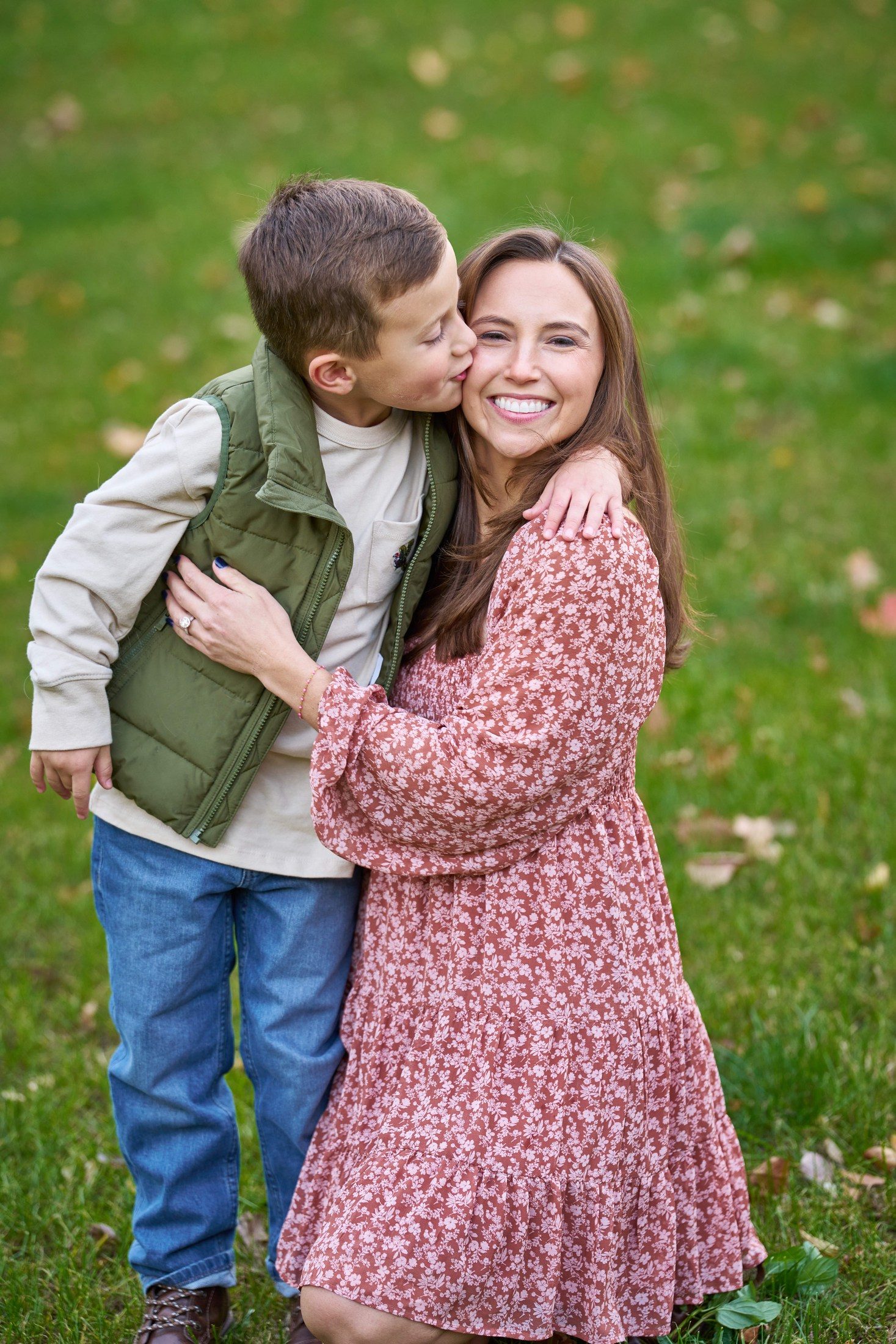The Engles’ son kissing Beth on the cheek during their backyard family portraits in Orono, Minnesota
