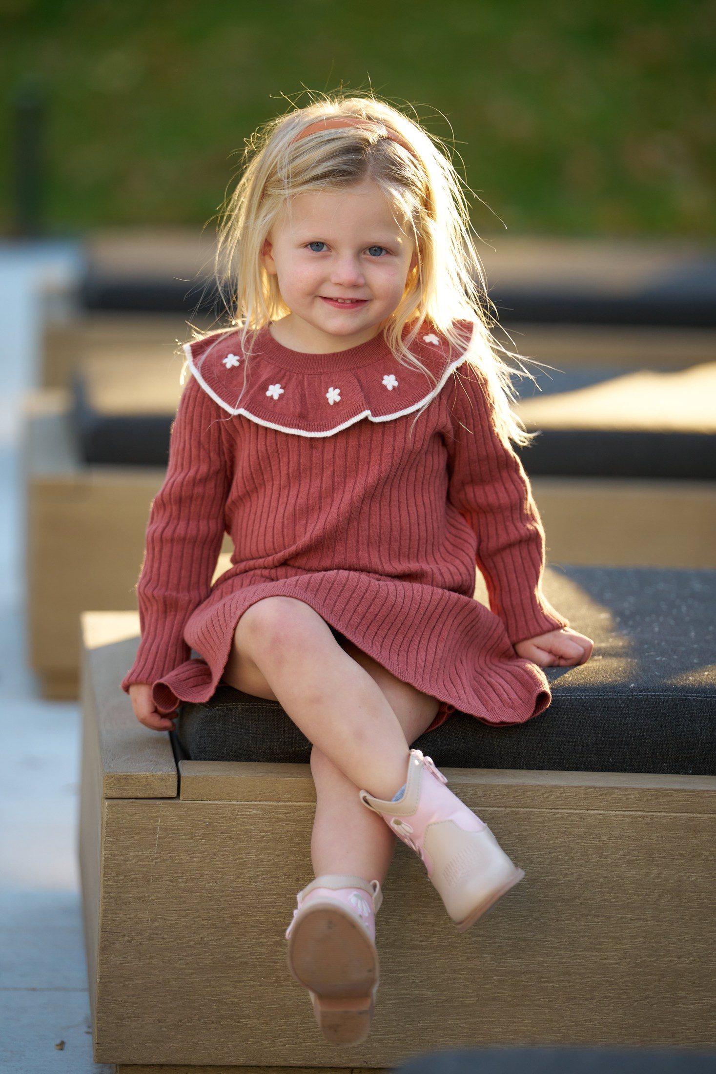 The Engles’ daughter sitting on a porch chair with sunlight in her hair in Orono, Minnesota