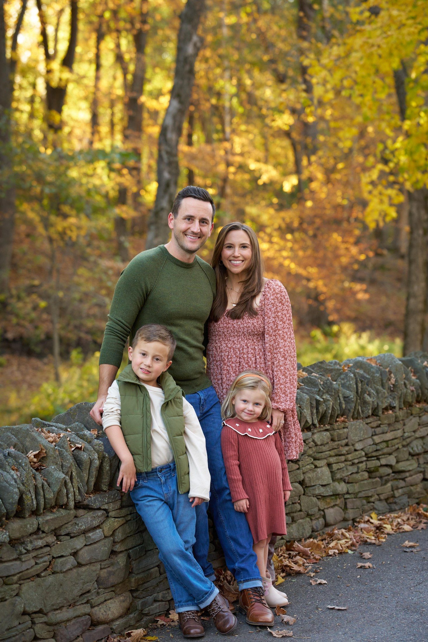 The Engle family beside an old stone wall beneath golden autumn trees in Orono, Minnesota