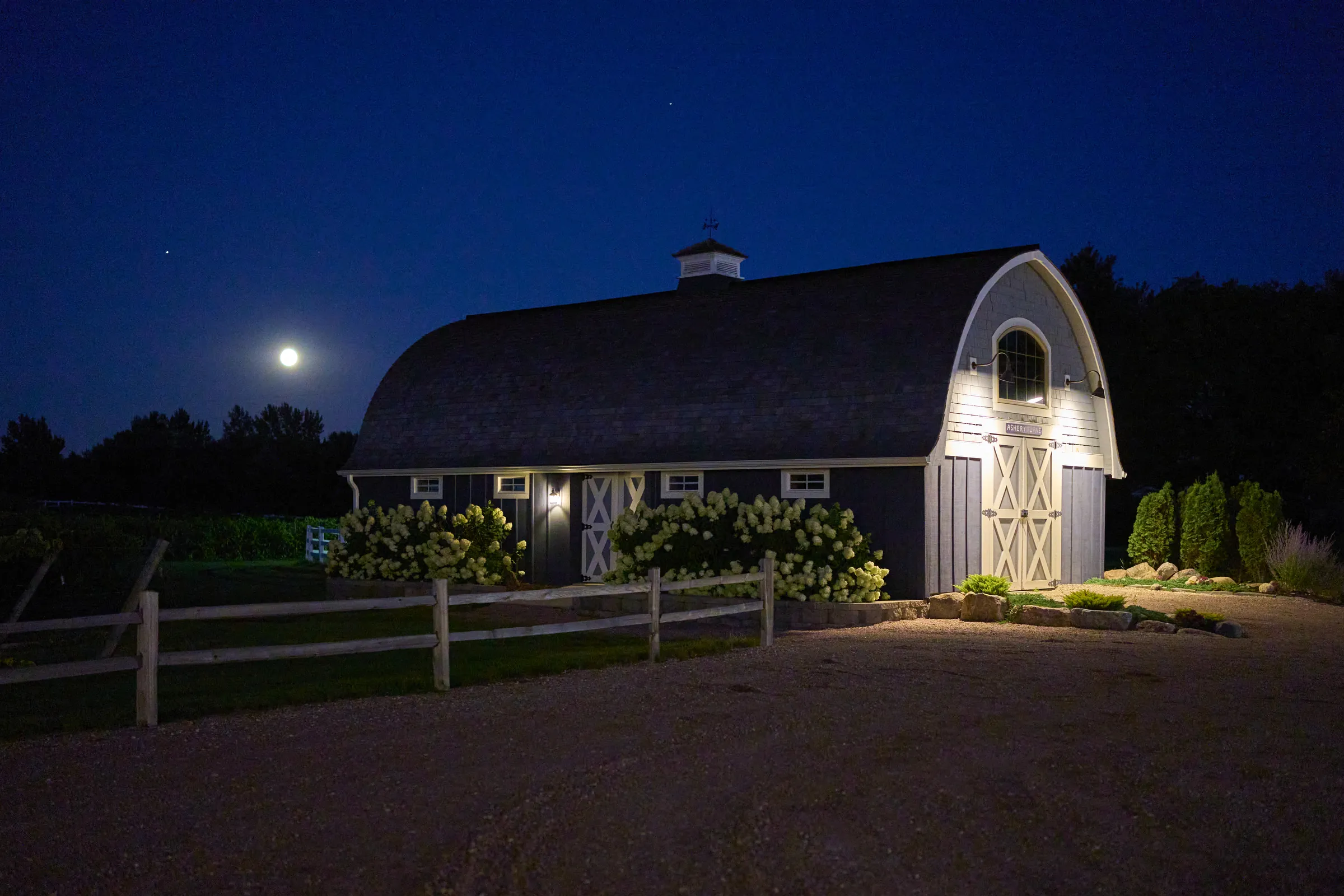 A lit barn beneath a deep blue night sky and a bright moon at Ashery Lane Farm, Ashery Lane Farm, Mayer, Minnesota