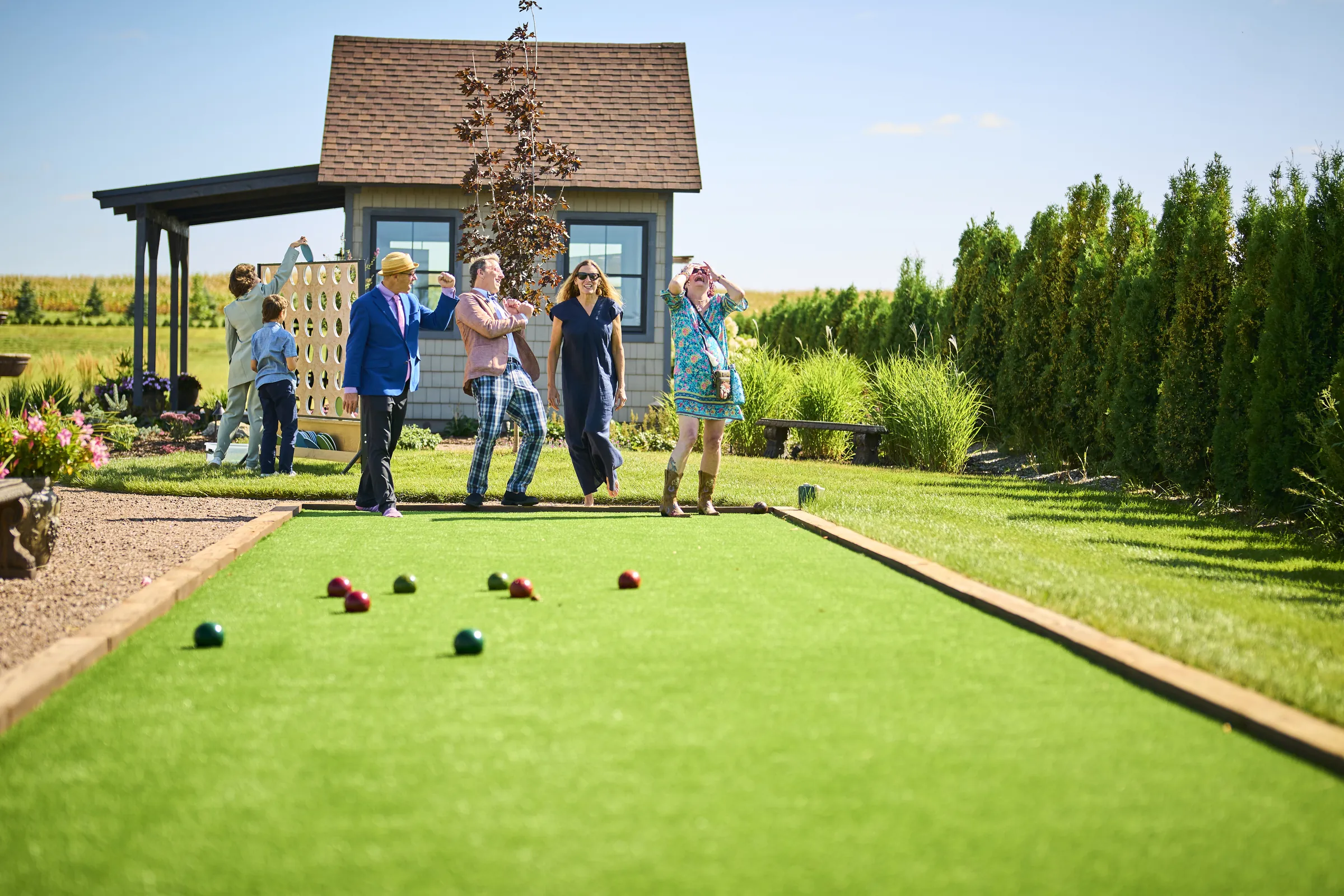 Guests play a lawn bowling game on a long court beside the garden buildings, Ashery Lane Farm, Mayer, Minnesota