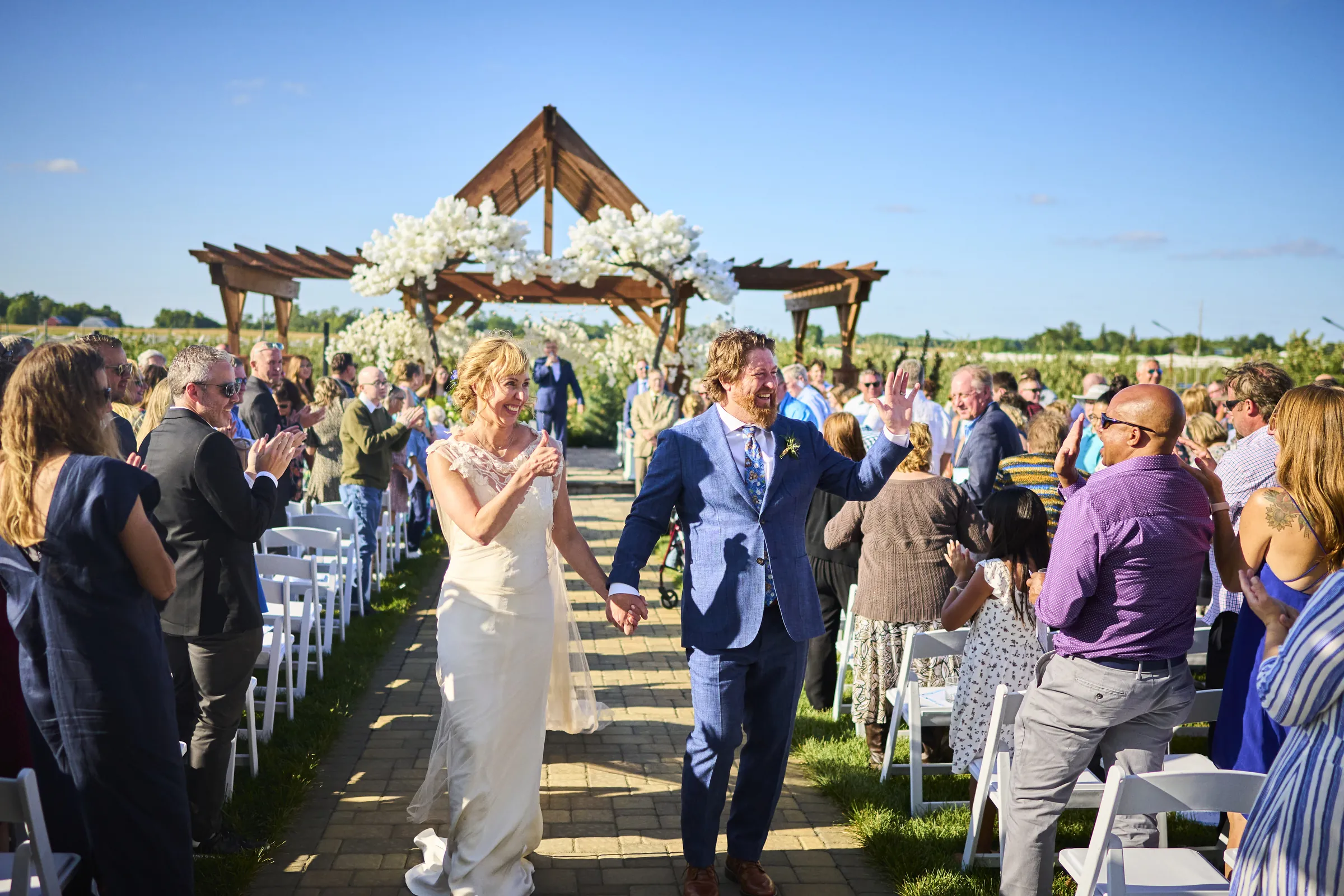 Jeanne and Brian smile as they walk back down the outdoor aisle together after their wedding ceremony, Ashery Lane Farm, Mayer, Minnesota