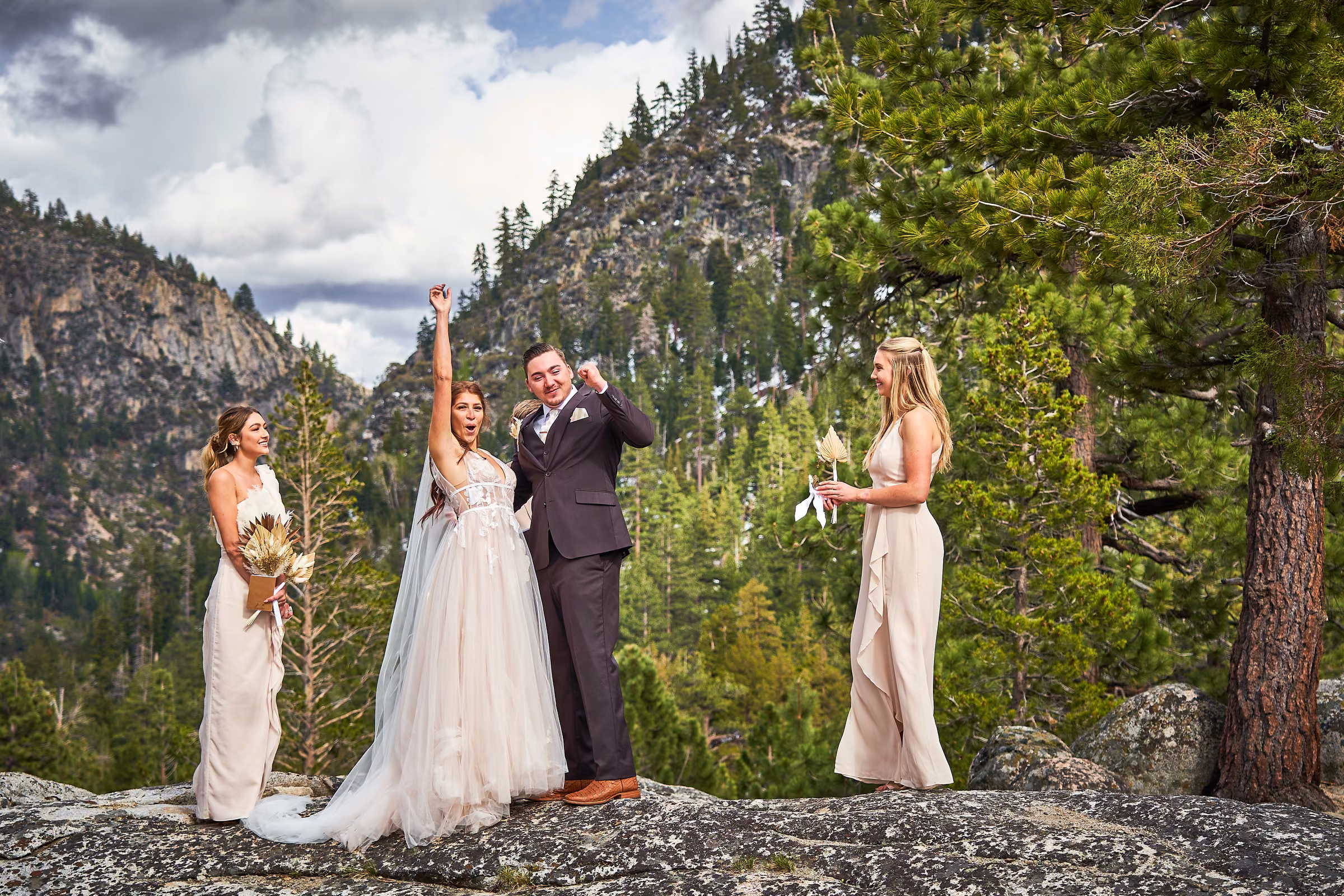 Joe and Gabby kiss during their outdoor wedding ceremony on a rock overlooking the mountain valley, Hope Valley, California