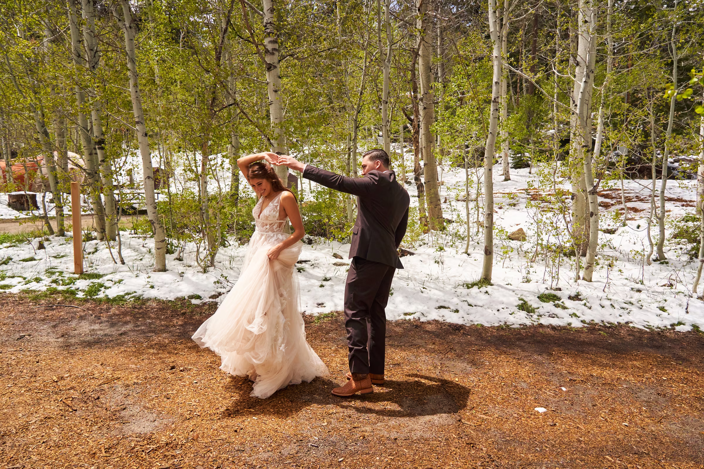 Joe turns Gabby in her wedding dress on a wooded path during their first look, Hope Valley, California