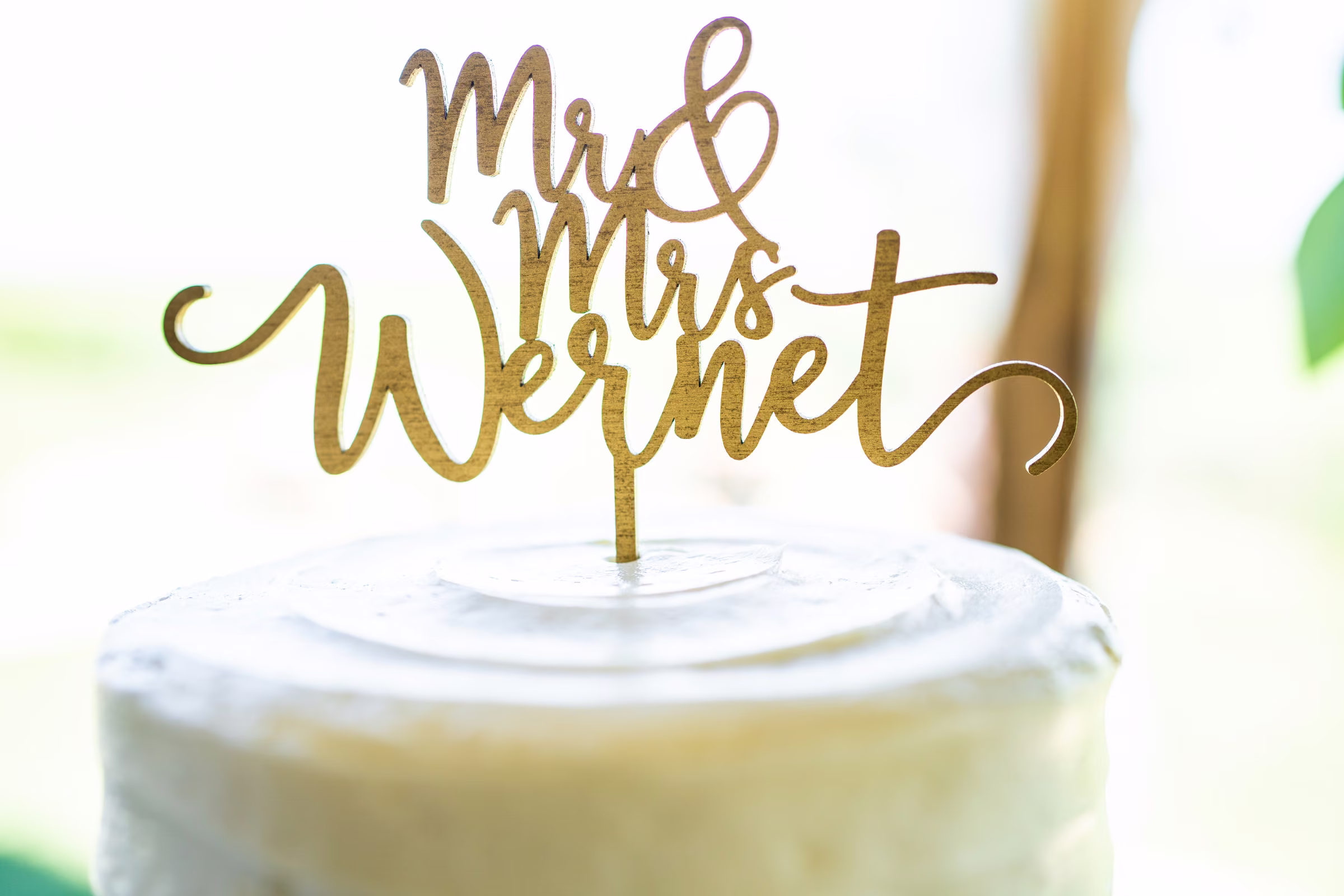 Gold Mr. and Mrs. Wernet topper on Katie and Tobias’s white wedding cake