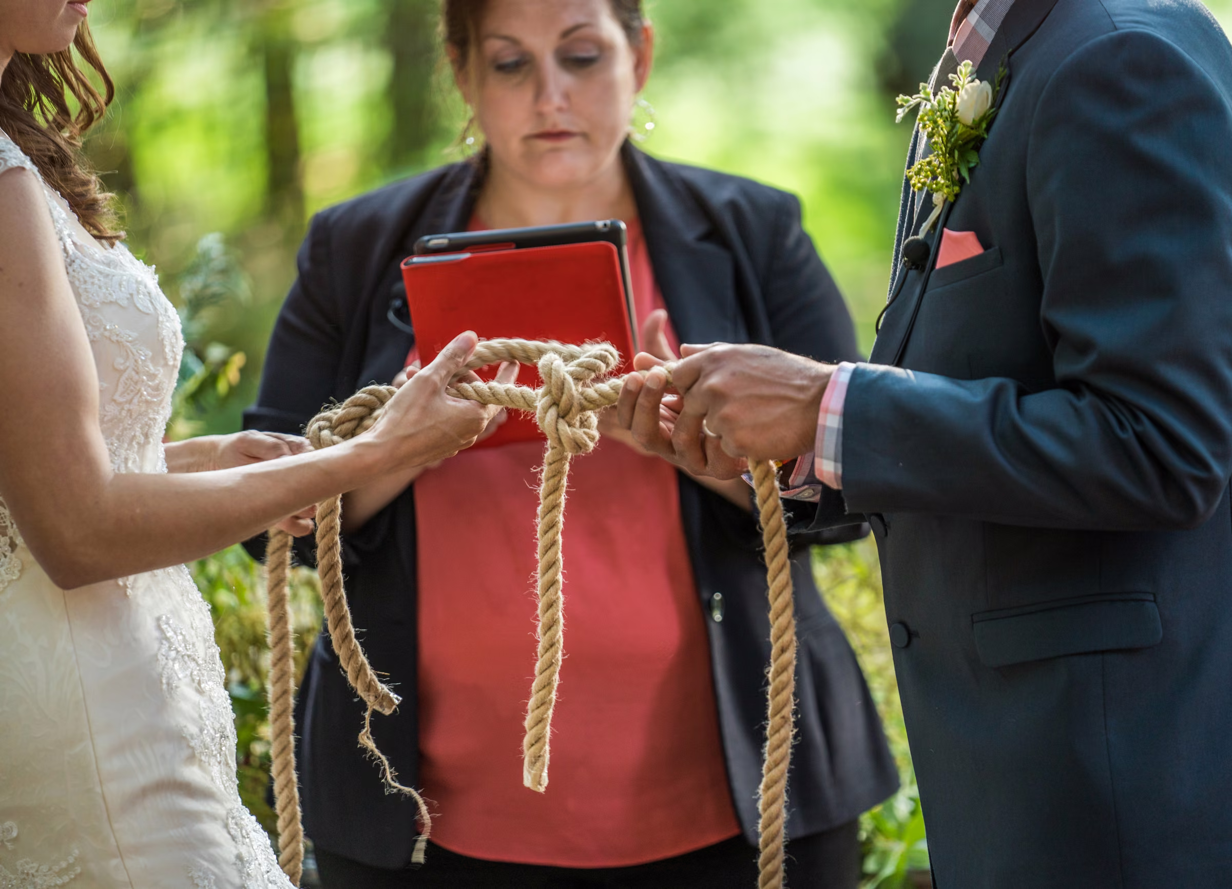 Kohleen and Kash tie a rope knot together during their wedding ceremony