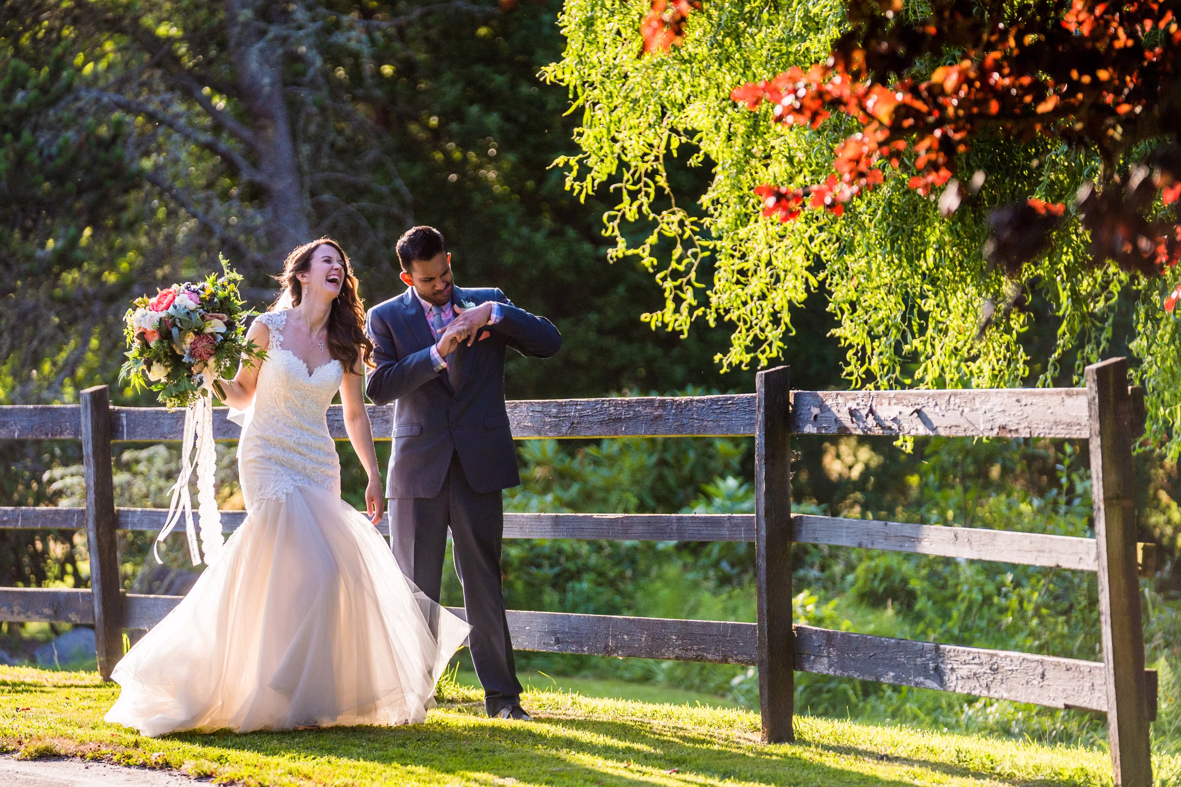 Kohleen laughs as Kash pretends to struggle with his wedding ring while they walk beside a fence