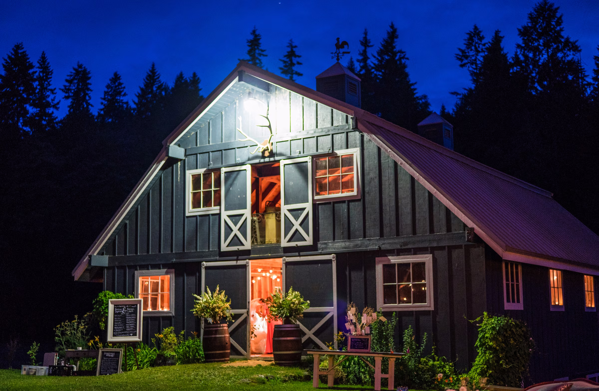 The illuminated blue barn glows beneath a deep blue night sky