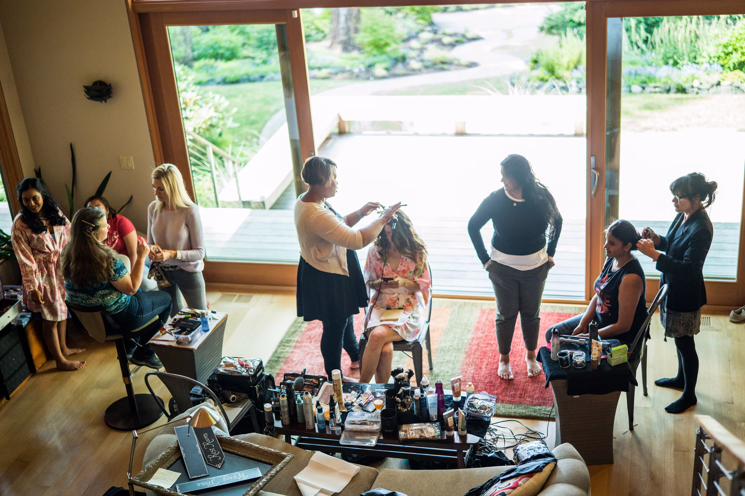 An elevated view shows Kohleen and her friends having their hair and makeup done beside large windows