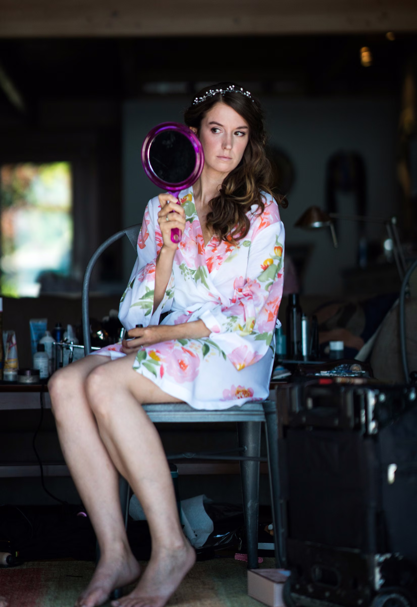 Kohleen holds a hand mirror while having her makeup finished