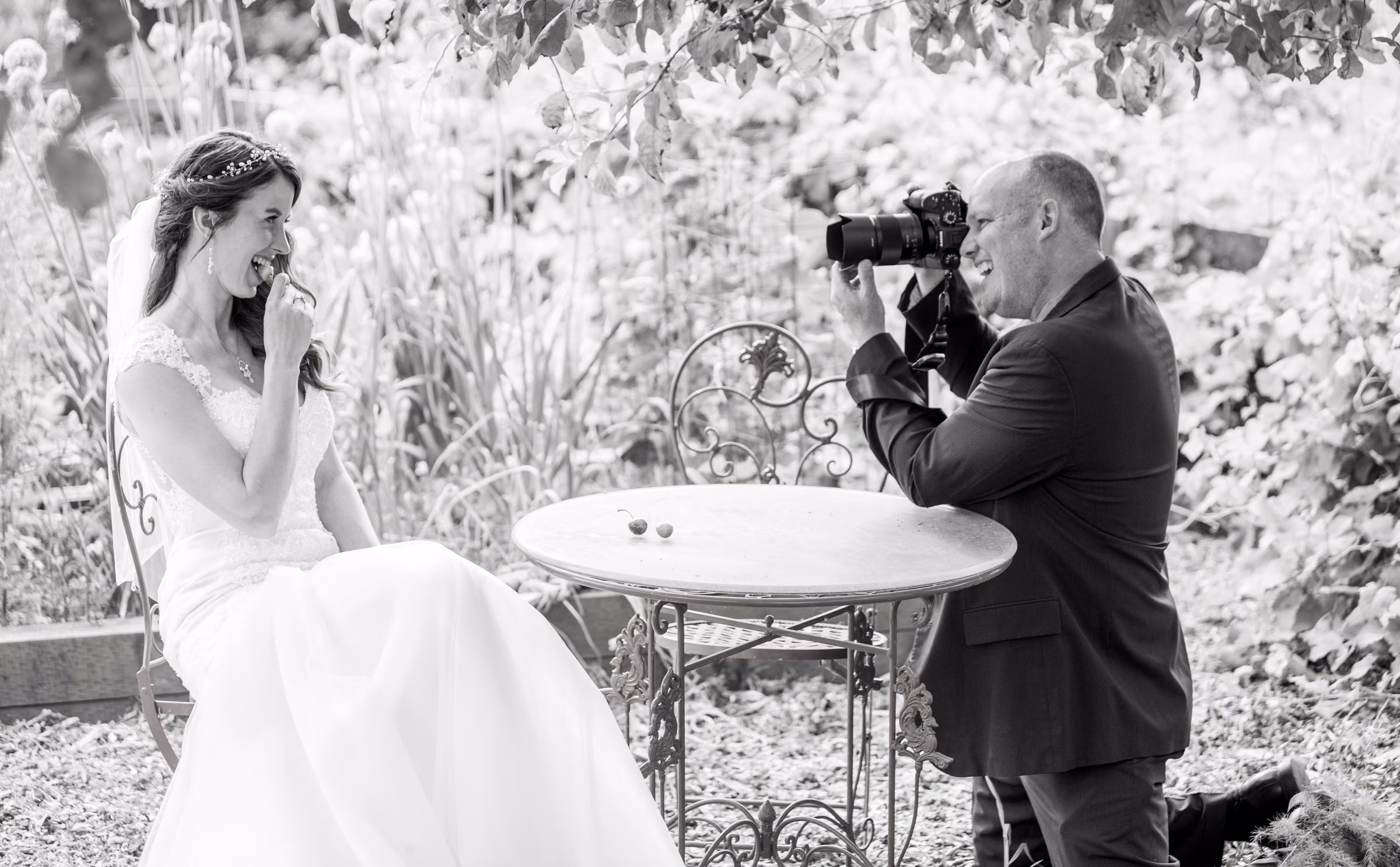 Robert Evans photographs Kohleen at a garden table in a black and white behind-the-scenes image