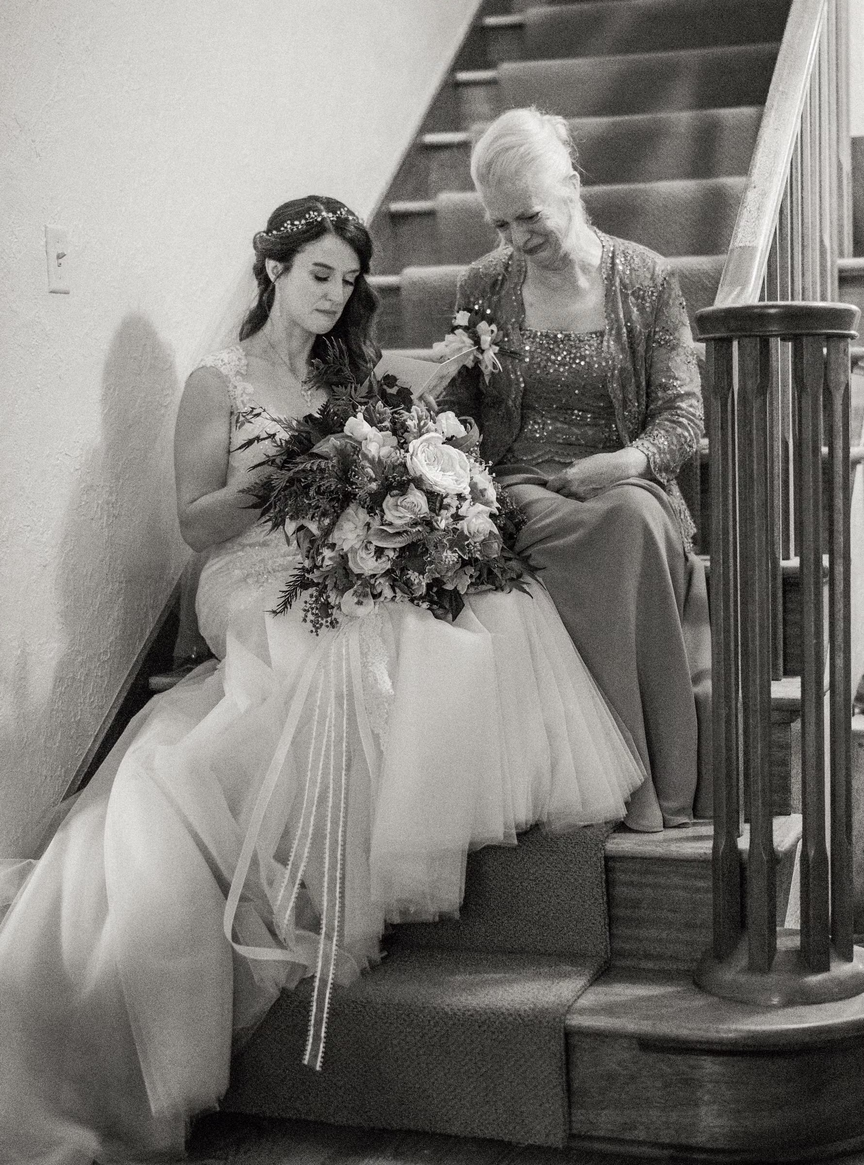 Kohleen reads a card from her mother as they sit together on the wooden staircase