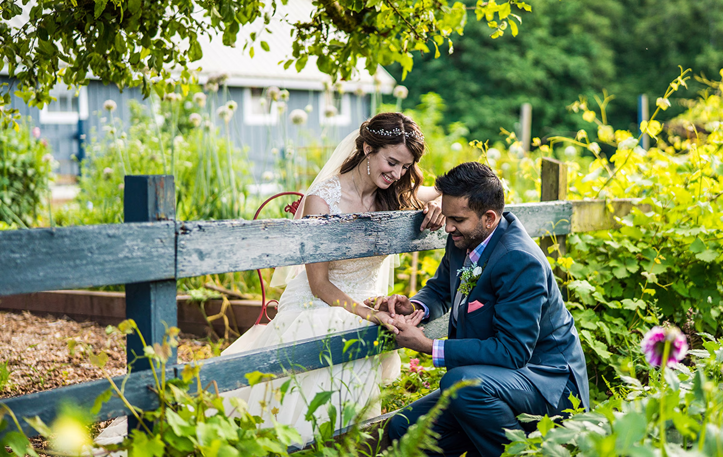 Kash traces a love note on Kohleen’s hand as they lean toward each other across a weathered farm fence